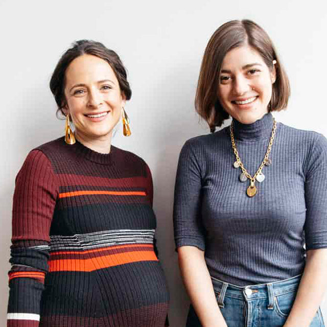 Claire and Erica stand together smiling, wearing Lizzie Fortunato earrings and necklace