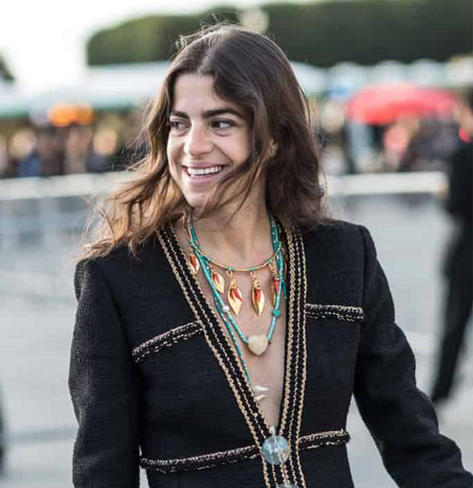 Woman on city street wears black boucle jacket with assorted Lizzie Fortunato necklaces