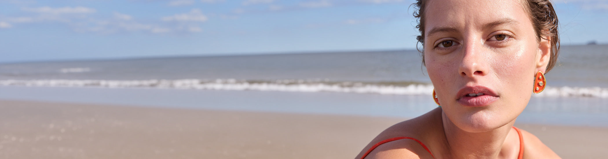 Model on beach wears white tank with Paros and Mare Cord Necklaces