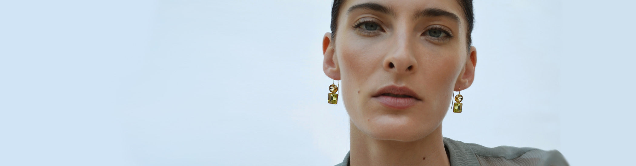 Model's face on blue backdrop, wearing Fine 14k gold Duo Earrings