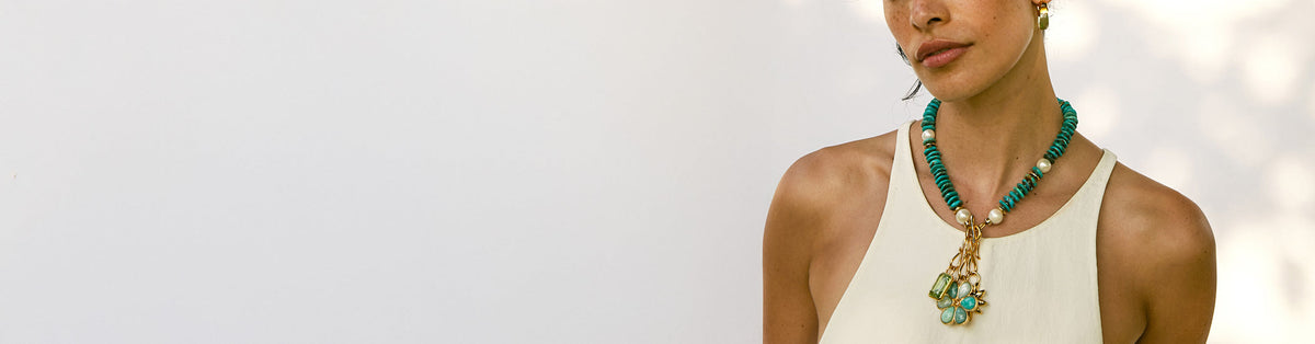 Model on grey backdrop wears white tank with Mood Necklace in Turquoise and assorted mood charms