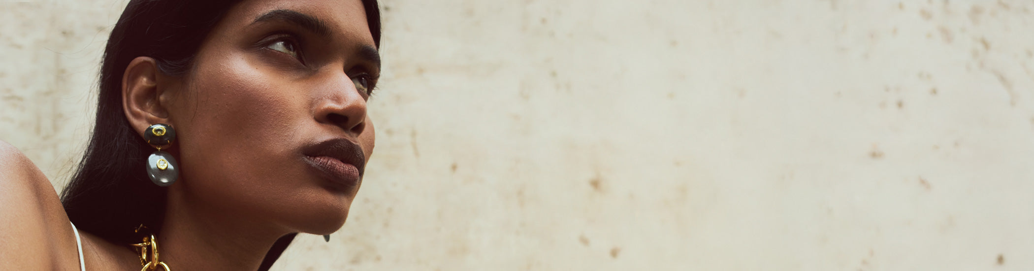 Model on stone backdrop wears Dorothy Earrings