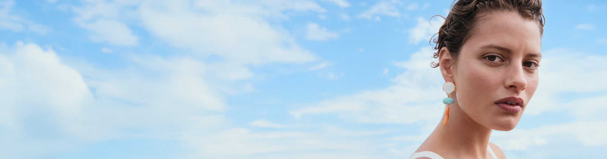 Model against blue sky and clouds wears Luna Drop Earrings