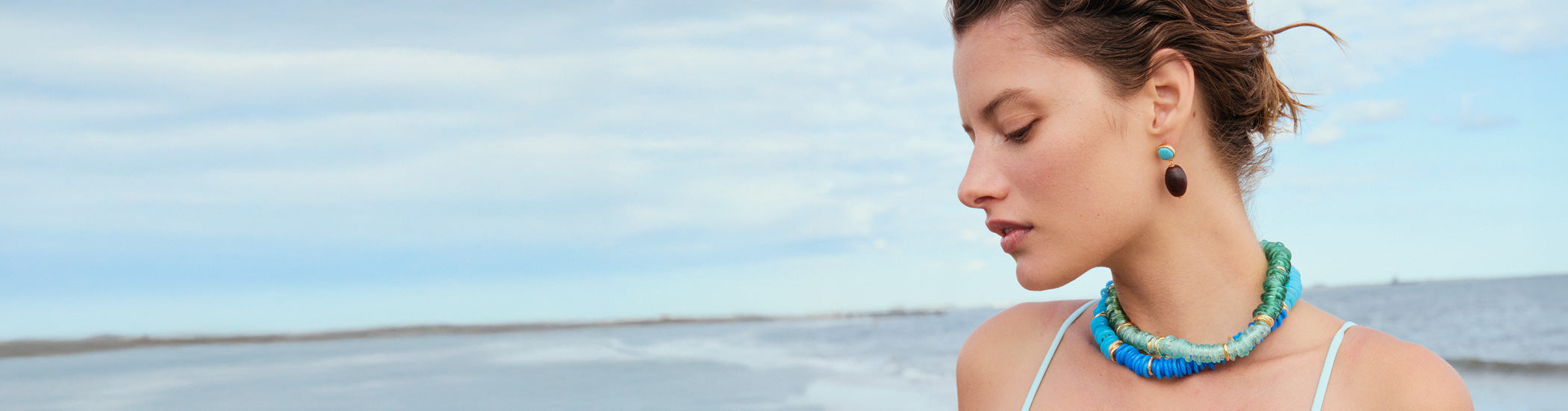 Model with ocean wears Lita Necklaces in Gimlet and Azzura, and Olea Earrings