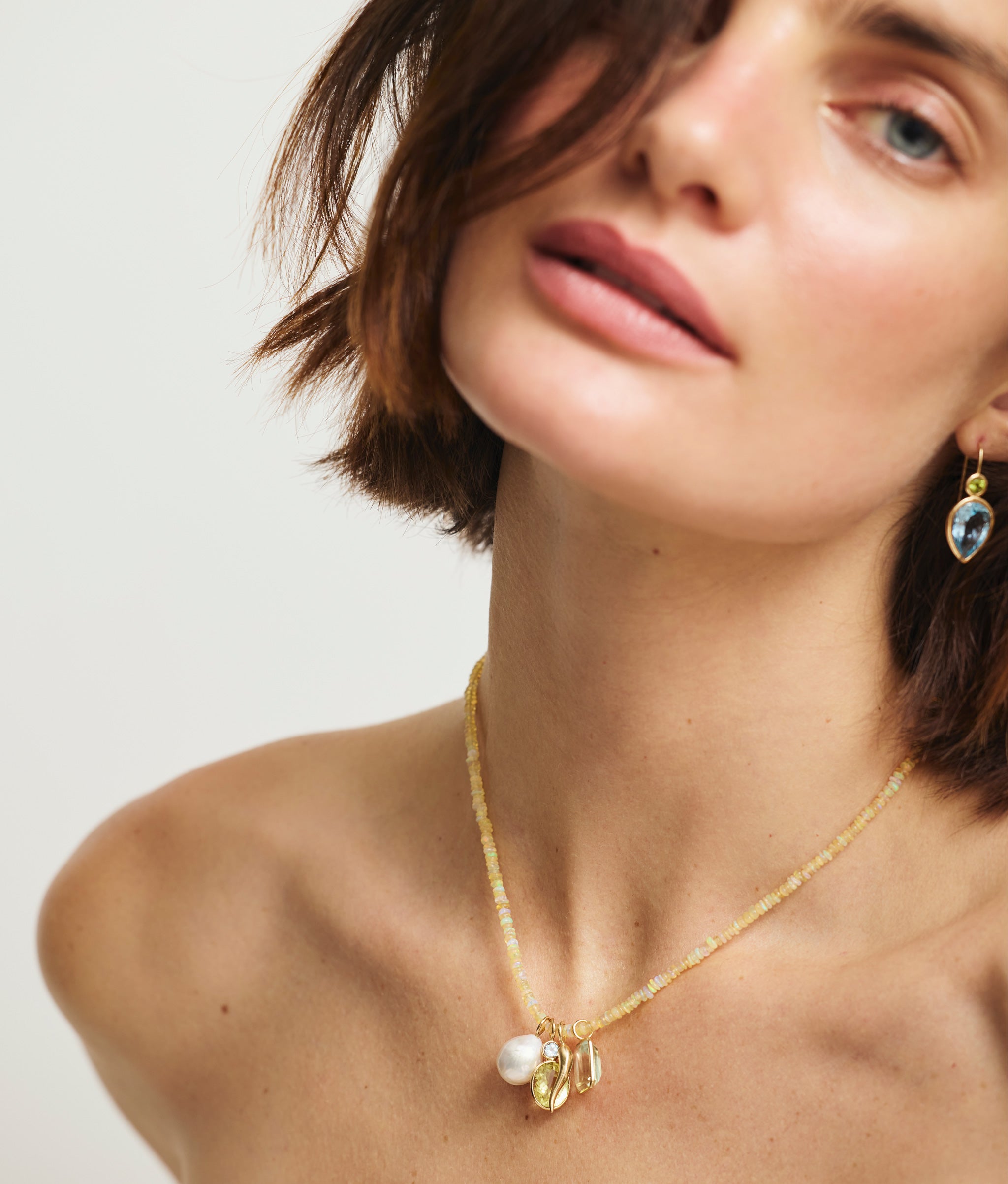 Model wears Fine Mood Charm Necklace in Opal Odyssey with Hera Earrings.