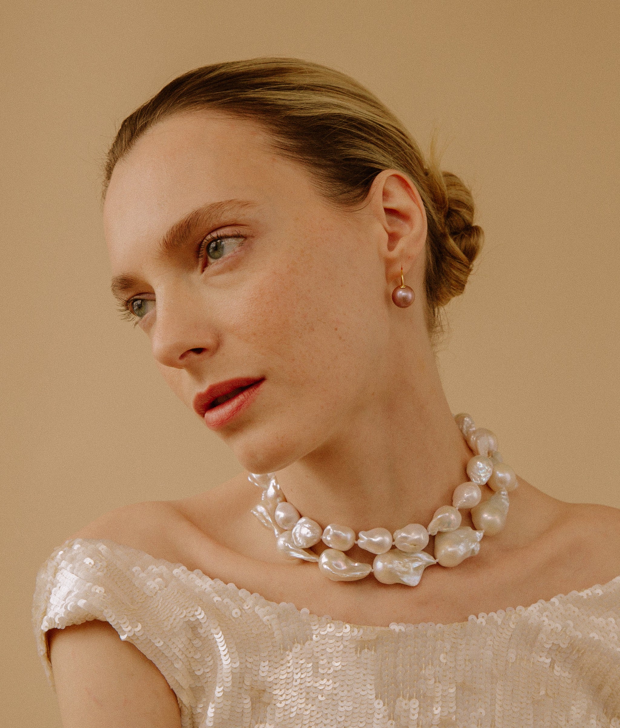 Model wears Claude Necklace on a yellow backdrop.