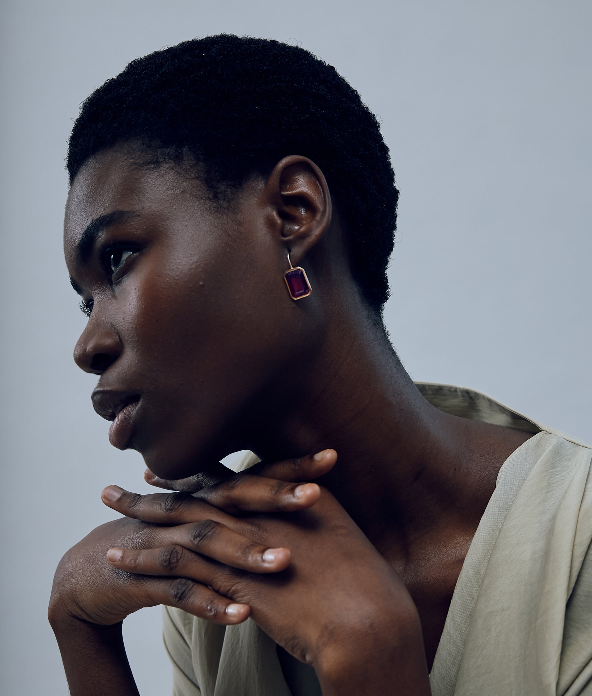 Model on grey background wearing the Aria Earrings in Hessonite Garnet.