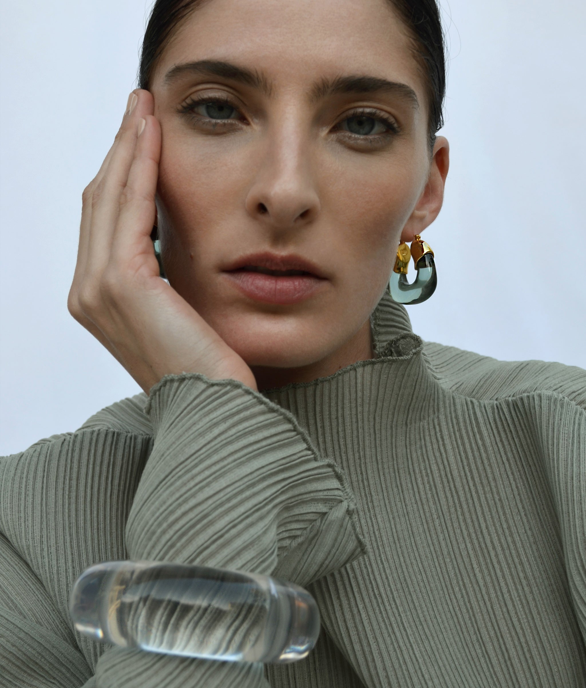 Model wears sage pleated top with Arc Cuff in Lilac and Organic Hoops in Forest.