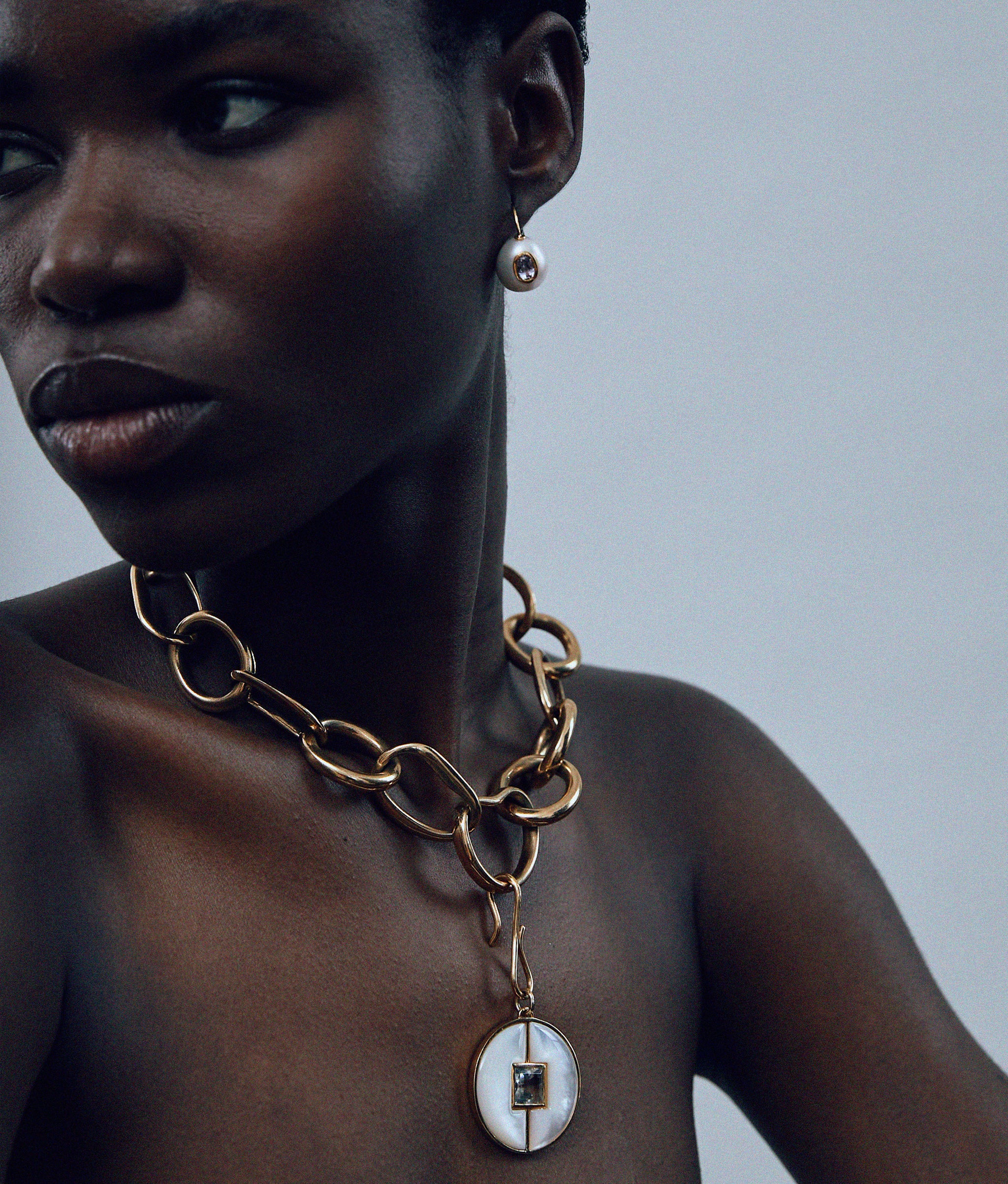 Close-up of model in Porto Chain in Gold with Porto Pendant in Mother-of-Pearl.