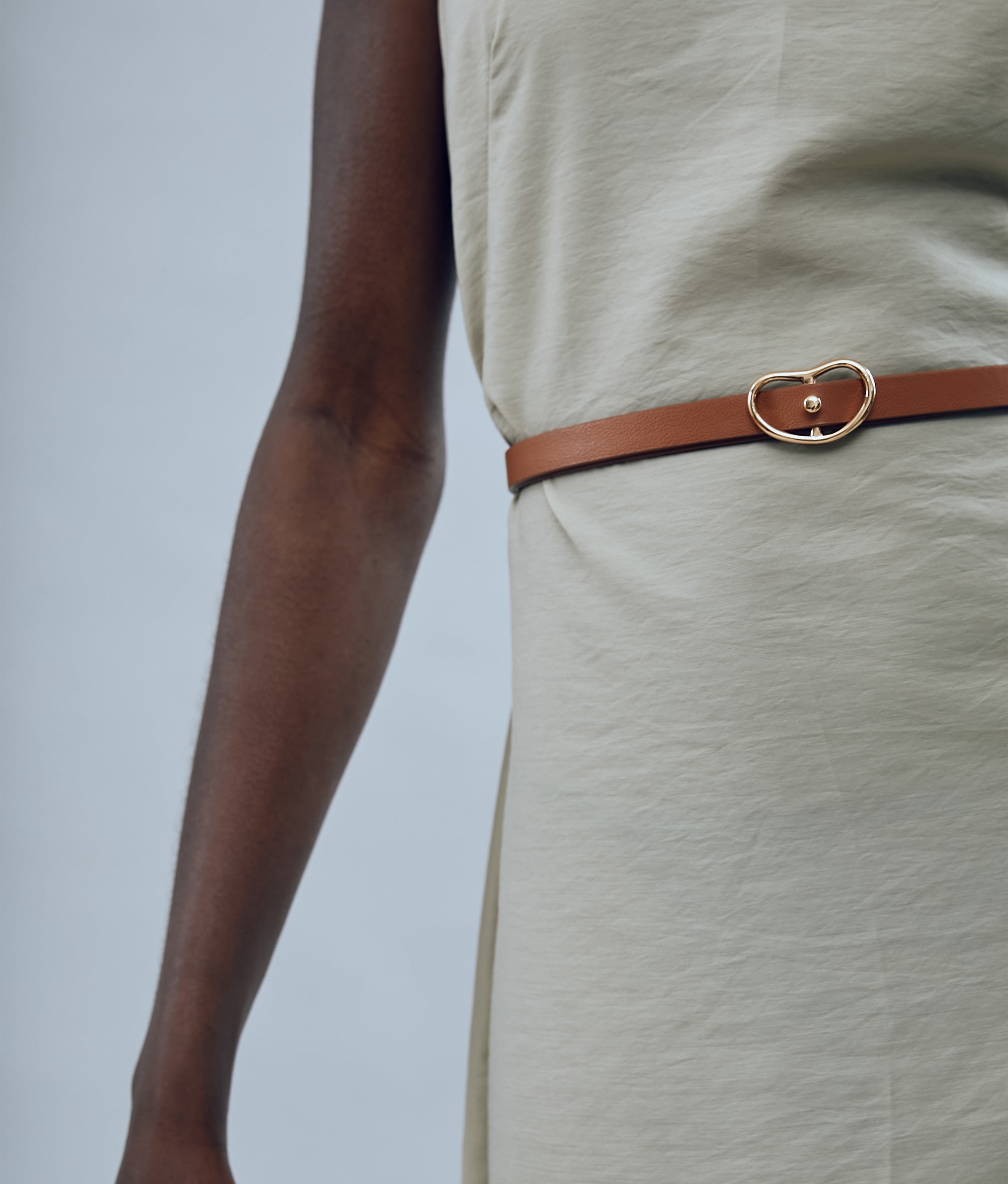 Close-up on model's waist, wearing tan dress and Skinny Georgia Belt