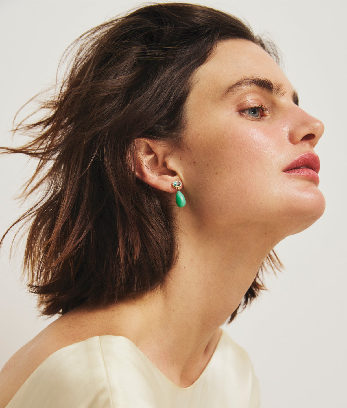 Side profile of a model wearing 14k Gold Drop Earrings in Green Topaz & Chrysoprase