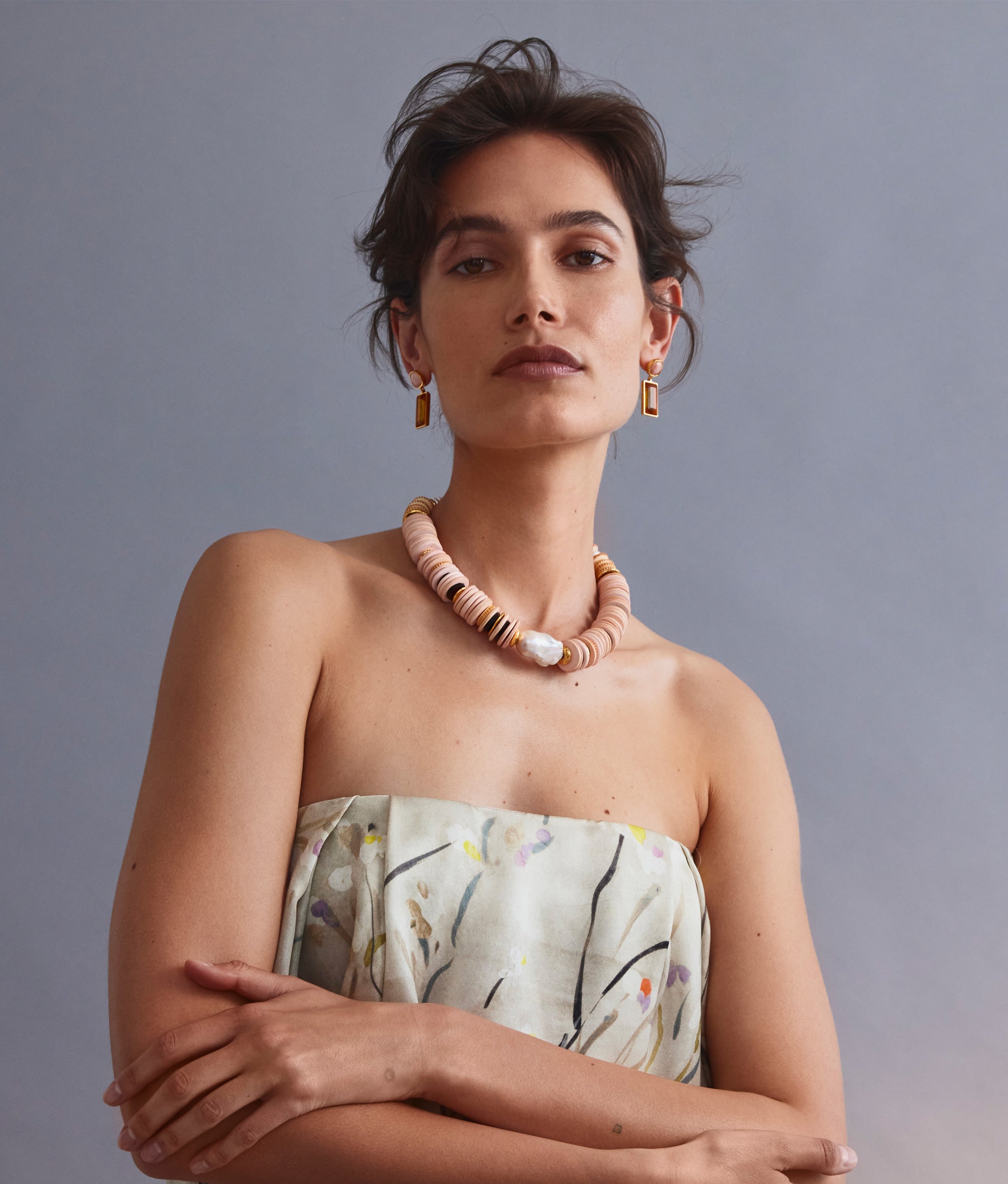 Model on grey backdrop wears strapless top with Crystal Column Earrings in Sunset and Goldsworthy Collar.