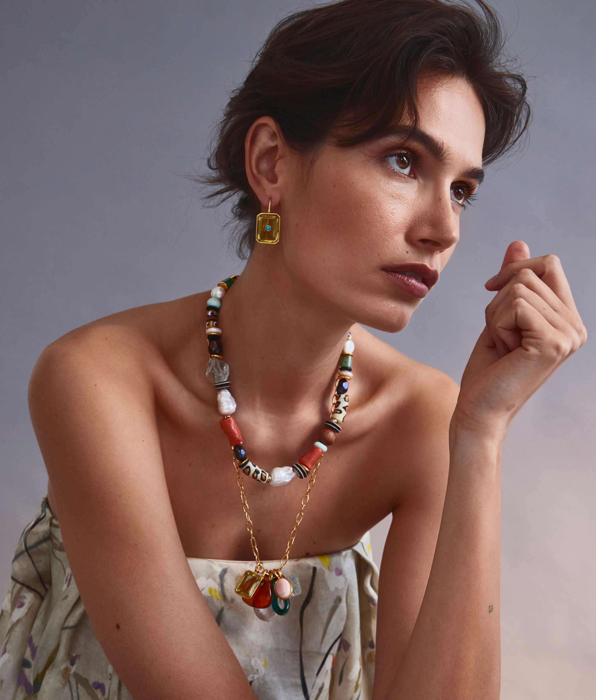 Model on grey backdrop wears dress with Eleuthera Charm Necklace, Salvador Necklace and Tile Earrings in Pineappleecklace and yellow Tile Earrings.