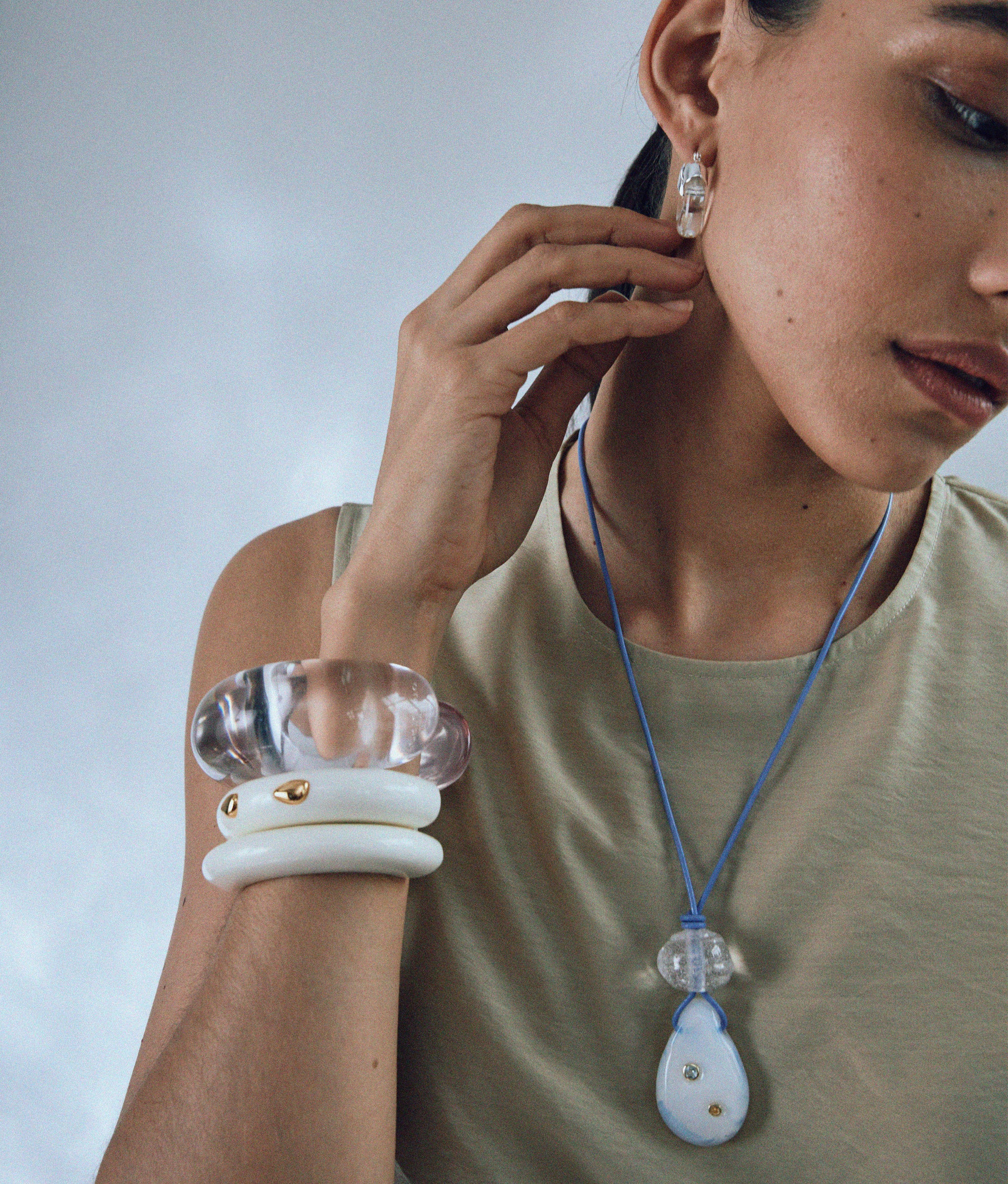 Model wears Ridge Cuff in Alabaster and Ridge Cuff in Alabaster and Gold Stud.