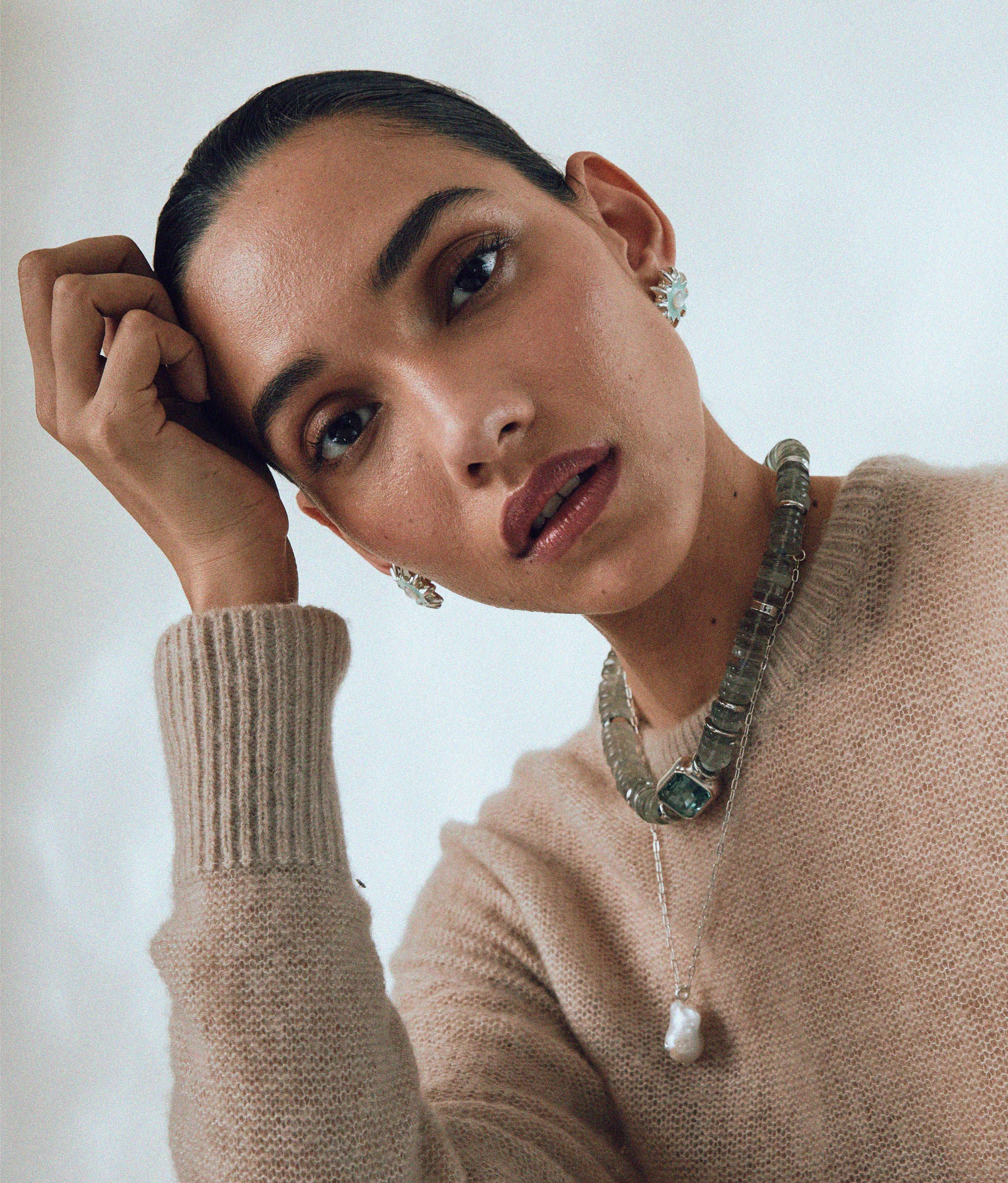 Model with hand on head wears tan sweater, Oasis Necklace in Silver, Goddess Collar and Helios Studs.