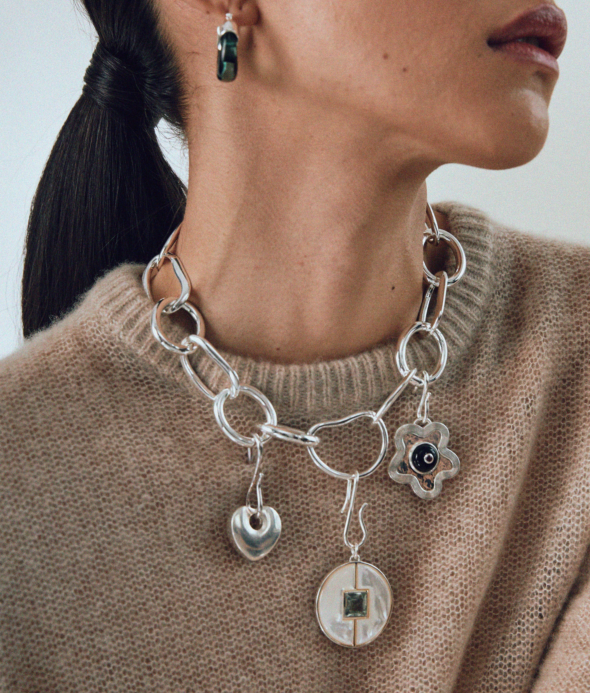 Close-up of model in tan sweater with Porto Chain in Silver and silver mood charms.