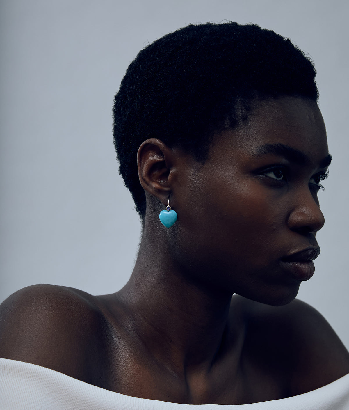 Close-up of model on grey background wearing the 14k Gold Amor Earrings in Tanzanite & Amazonite.