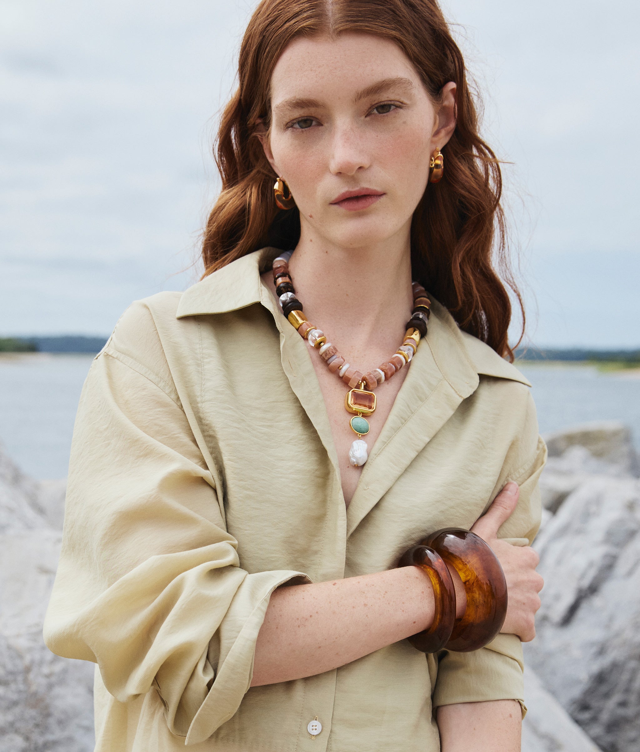 Model wearing Ridge Cuff in Tortoise, Arc Cuff in Tortoise, Mini Organic Hoops in Honey, and Capri Necklace in Dusk.