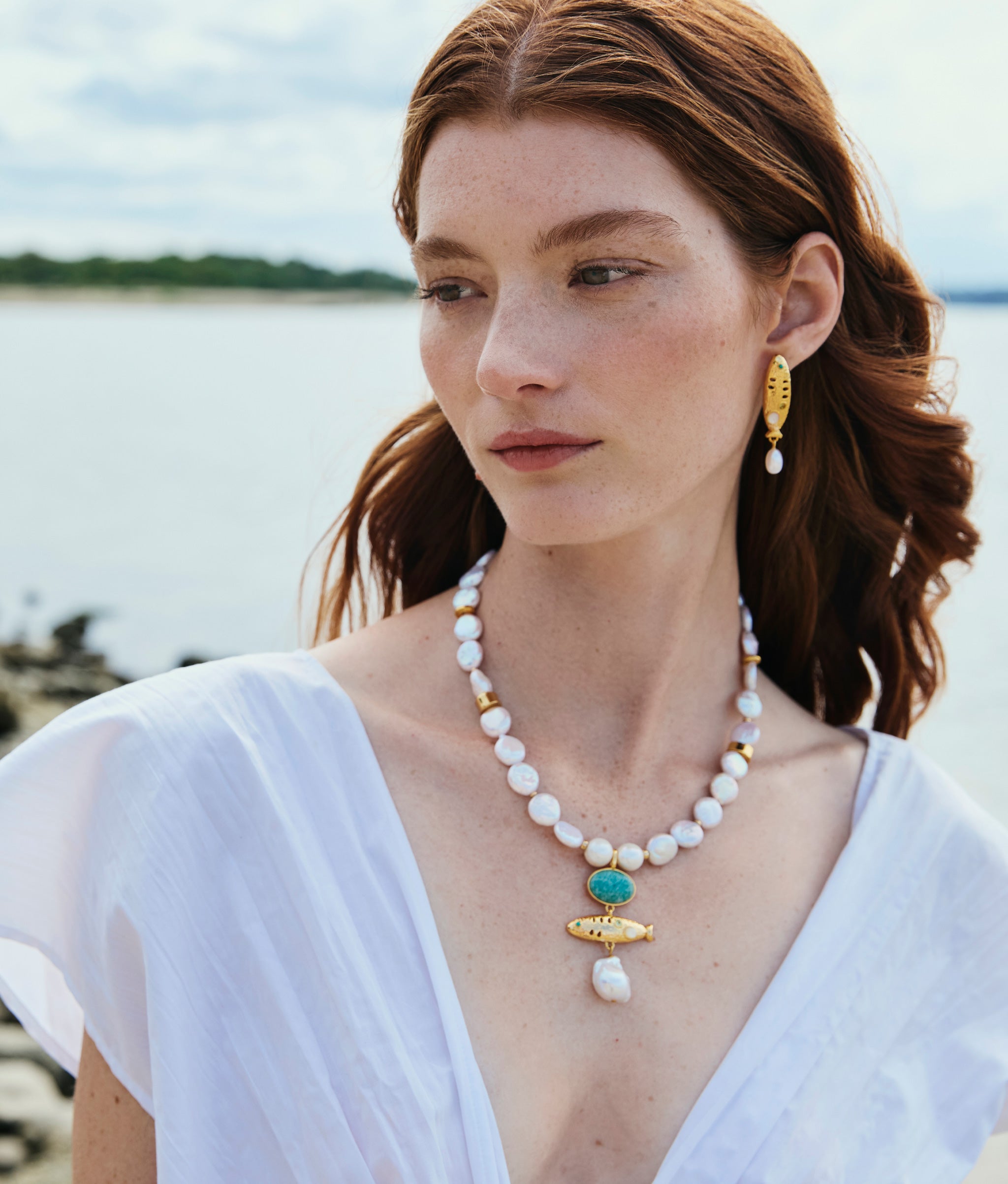 Model at water wears Sardinia Pearl Necklace and Sardinia Pearl Earrings.