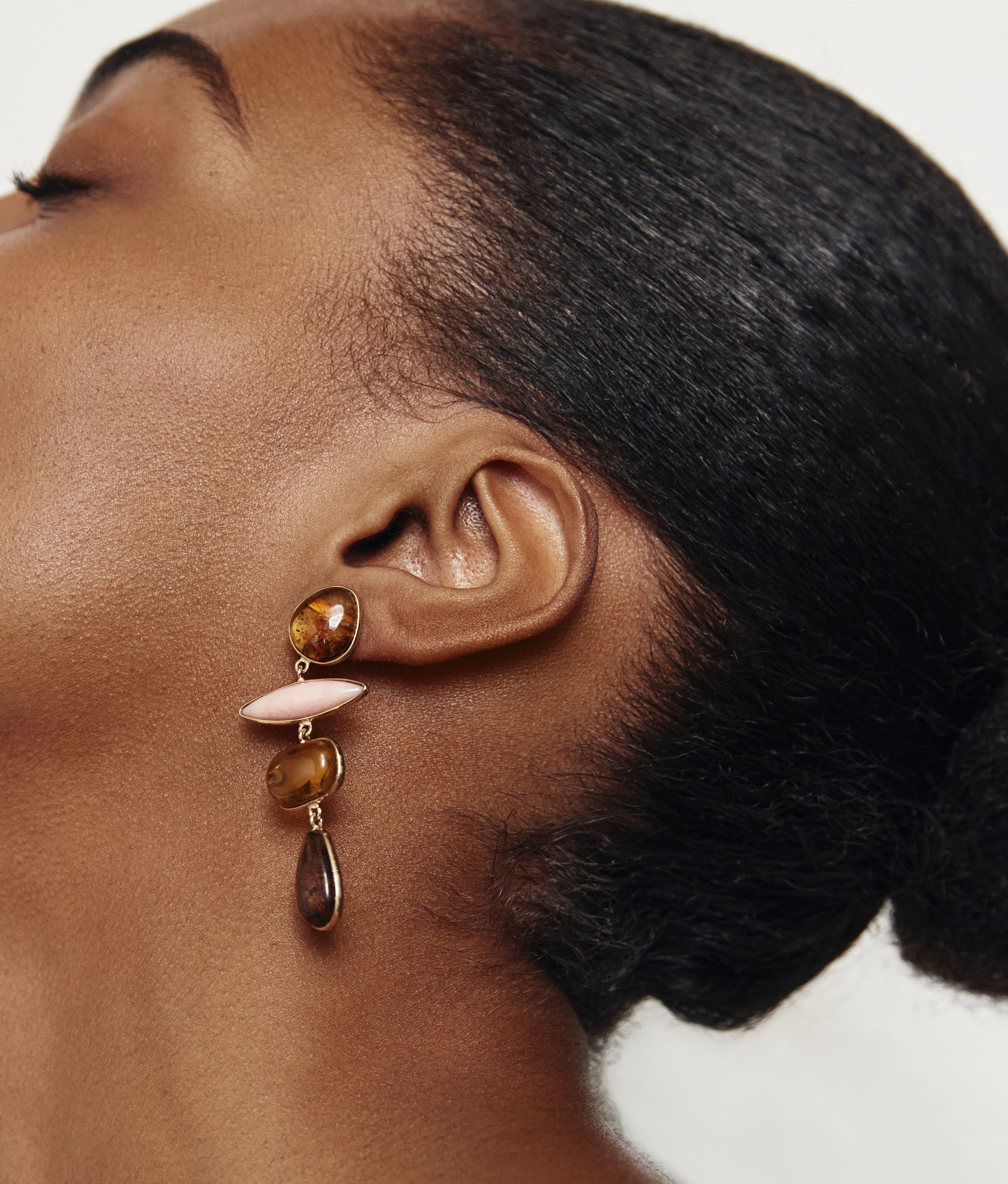 Close-up on model with head thrown back wearing 14k Gold Amber & Pink Opal Column Earrings.