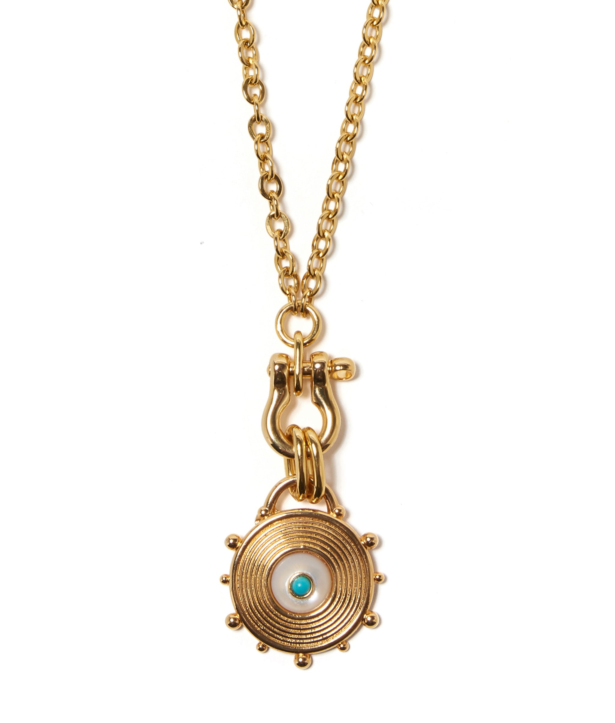 Close-up on gold-plated wheel pendant with mother-of-pearl cabochon and turquoise detail.
