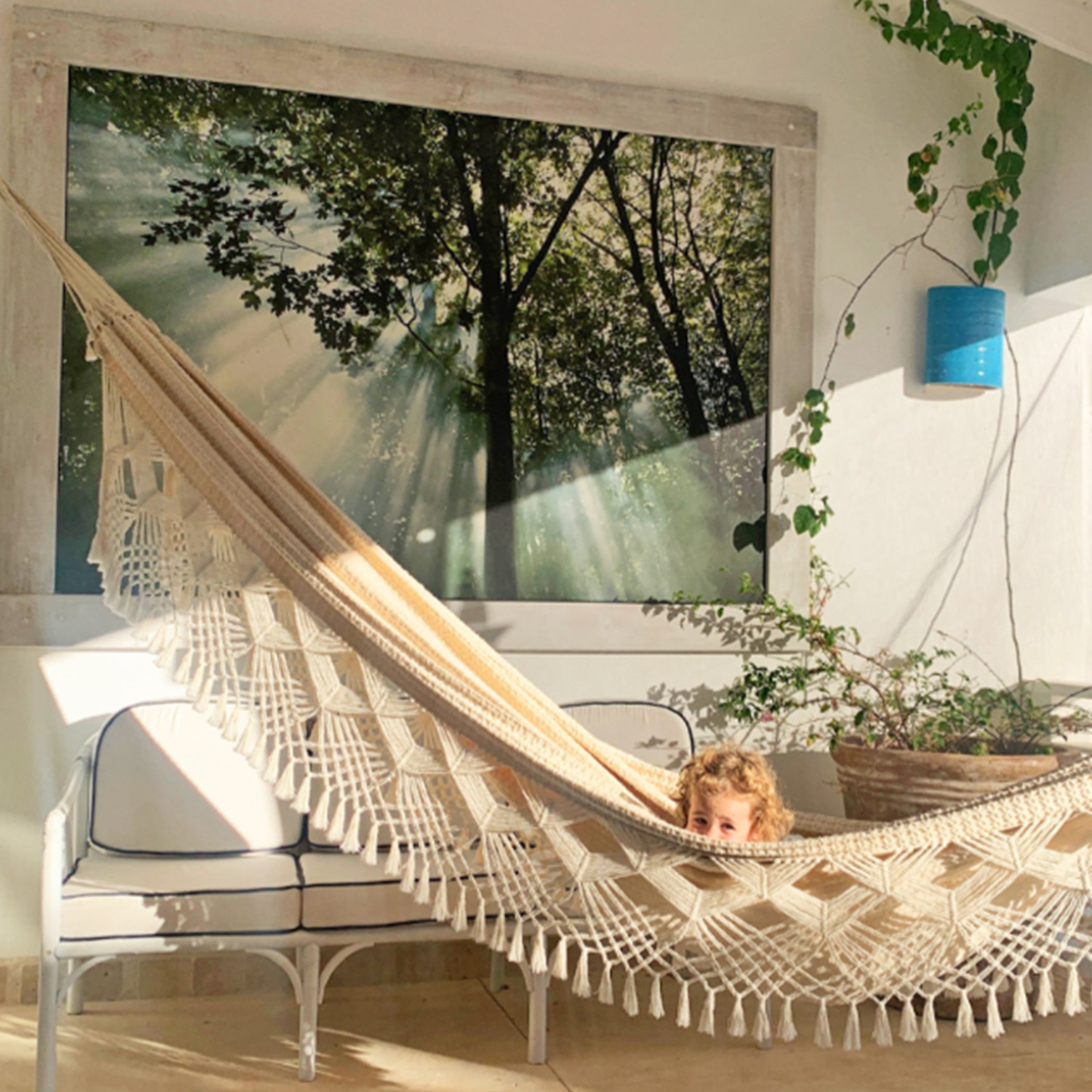 Tropical patio with toddler in string hammock