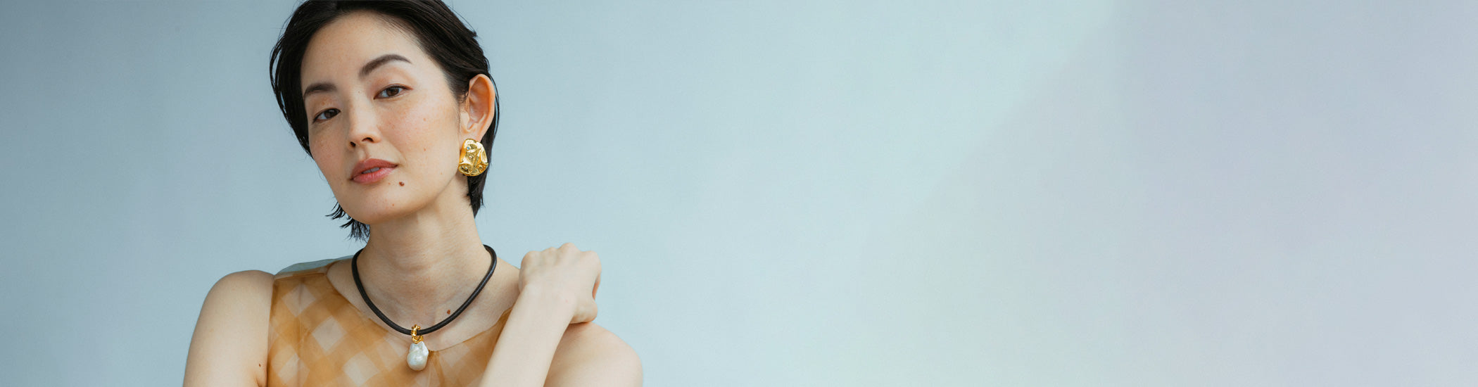 Model on tan background wears strapless tulle with Formation Earrings in Pearl