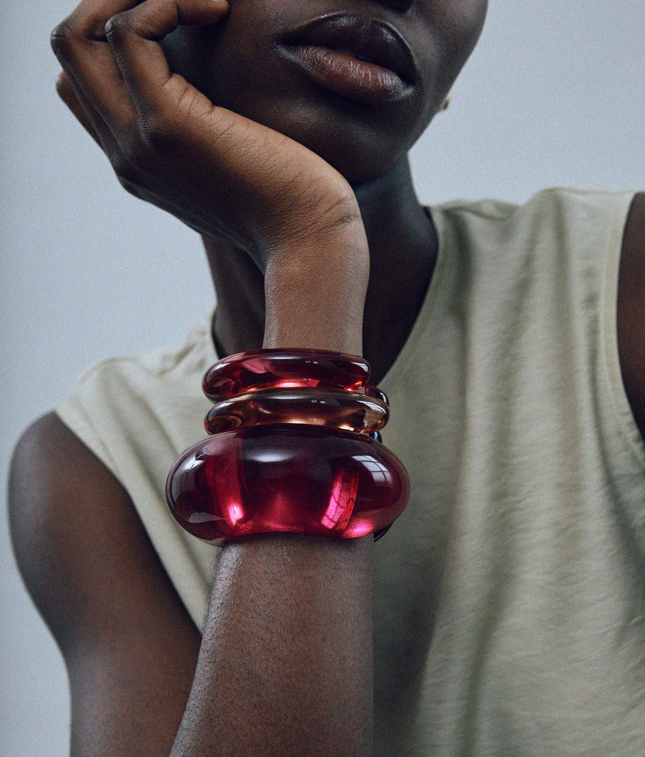 Model wearing Arc Cuff in Magenta paired with Ridge Cuffs in Magenta and Persimmon.