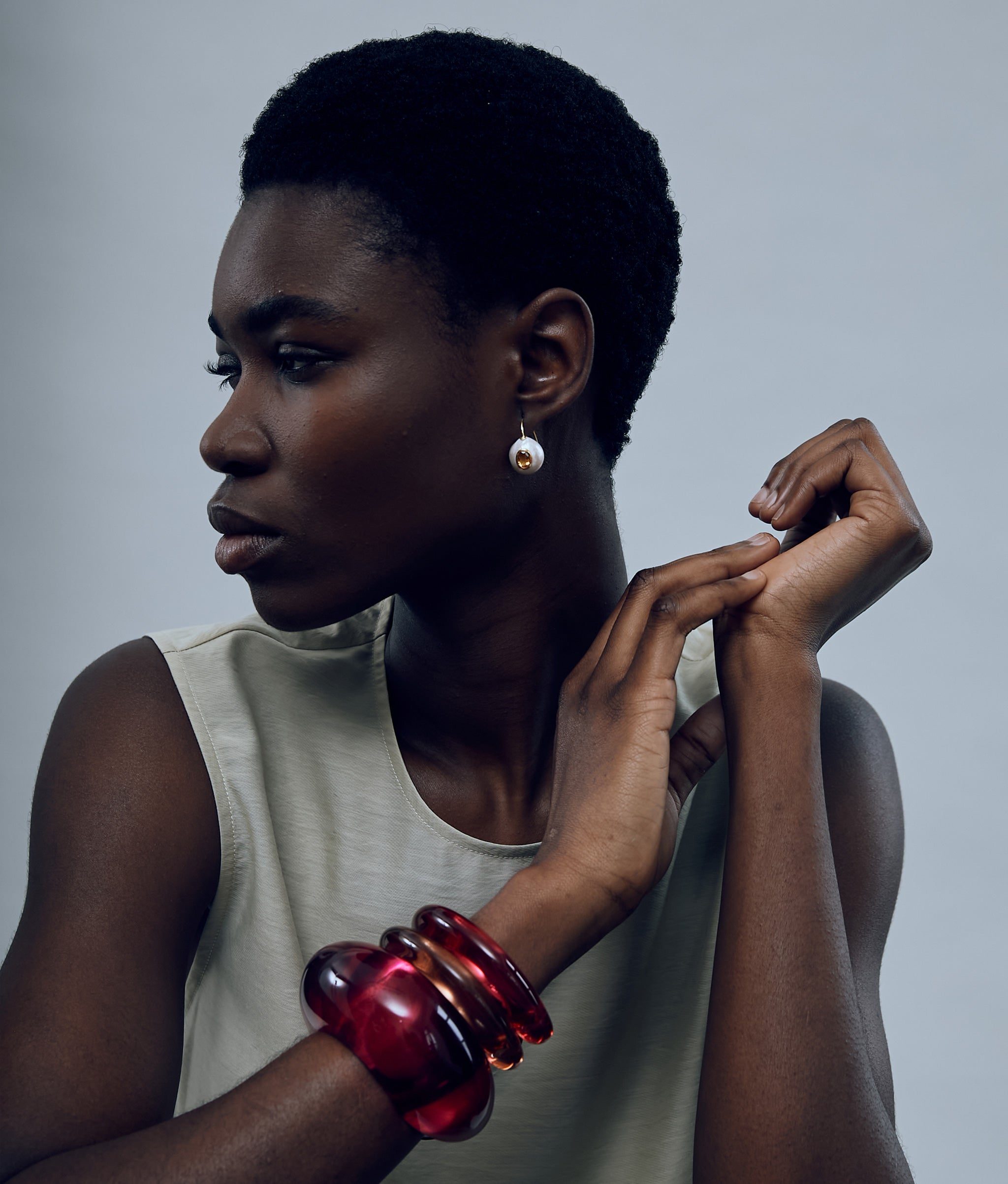 Model wearing Arc Cuff in Magenta paired with Ridge Cuffs in Magenta and Persimmon and Pearl Pablo Earrings in Citrine.