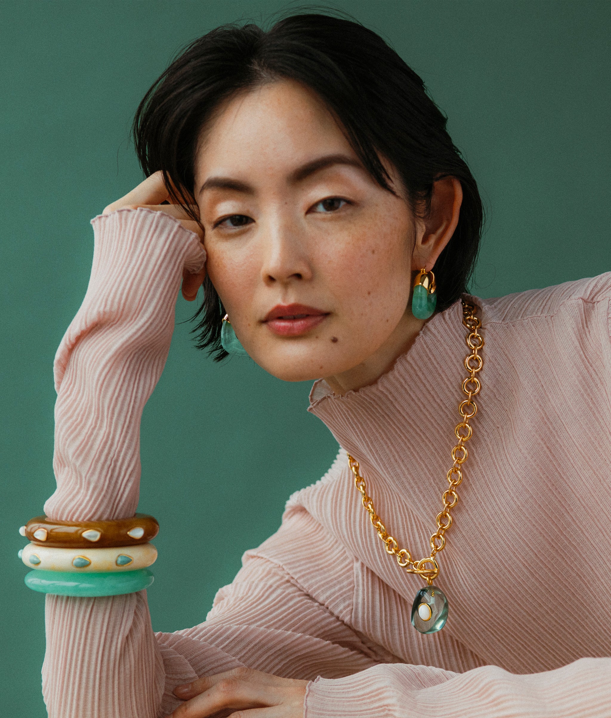 Model wears Ridge Cuff In Alabaster and Amazonite with Organic Hoops in Jade Green and Meteor Necklace In Sea