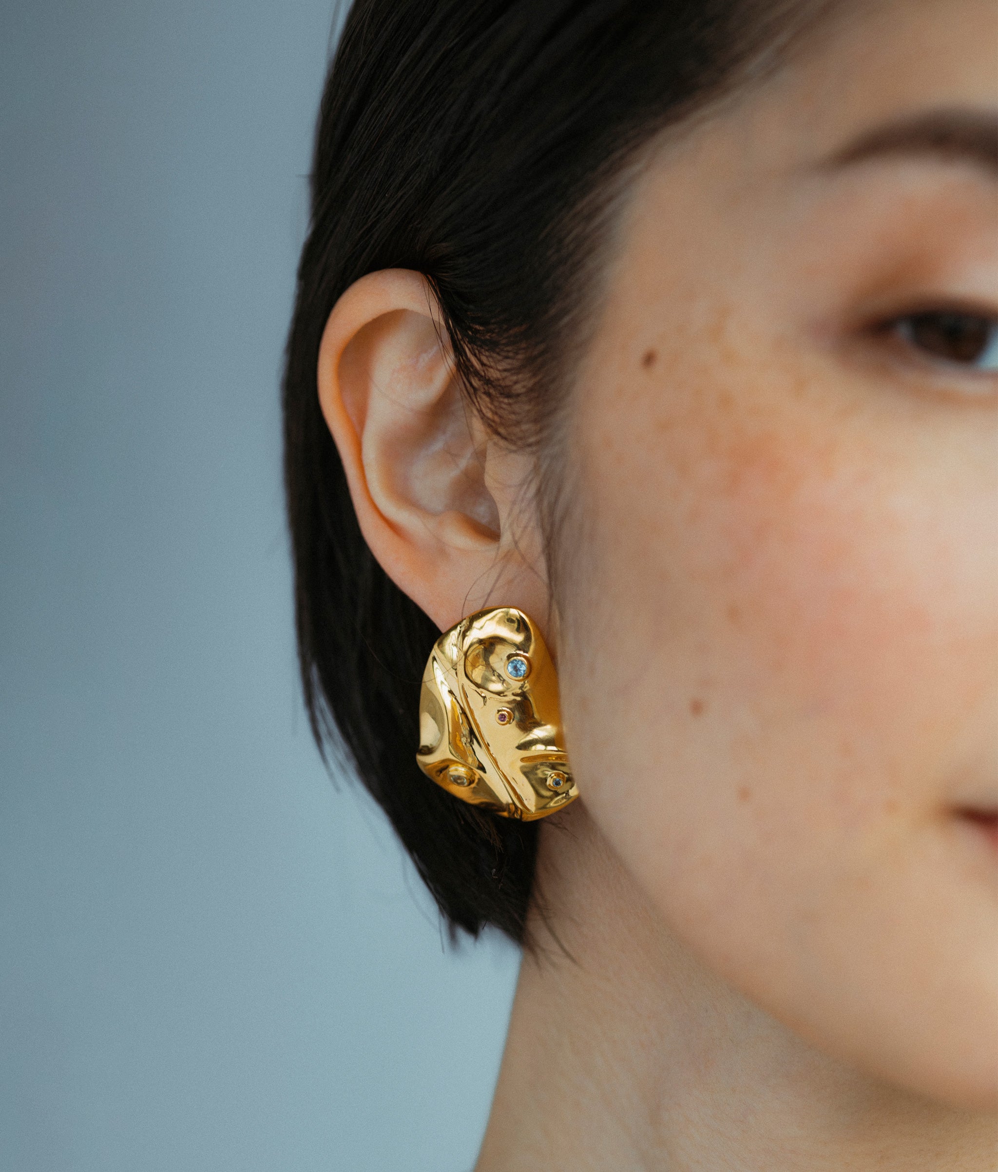 Close-up of Mazu Studs Earrings on model.