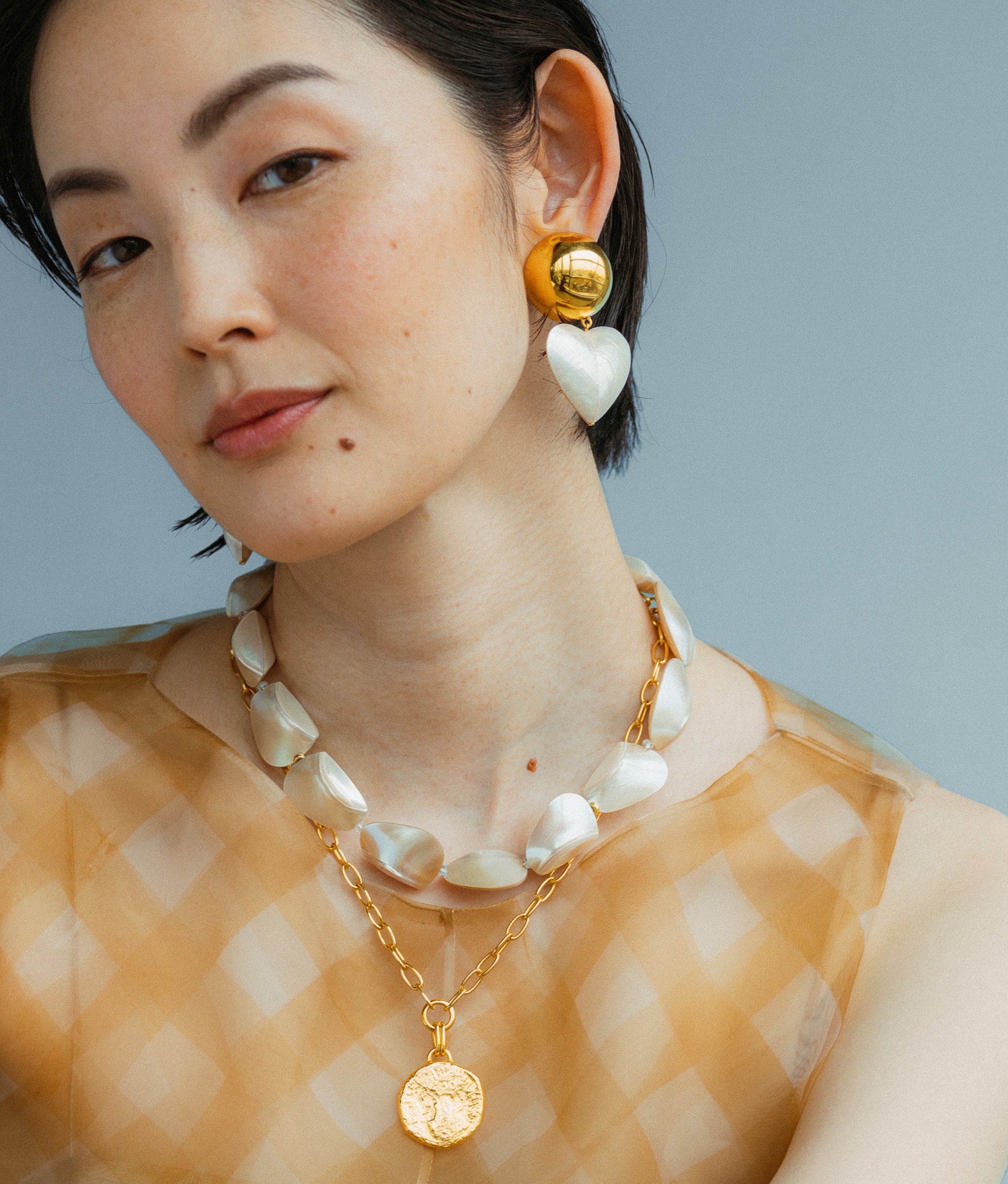 Model wears Rodan Heart earrings styled with Pas de Deux Necklace