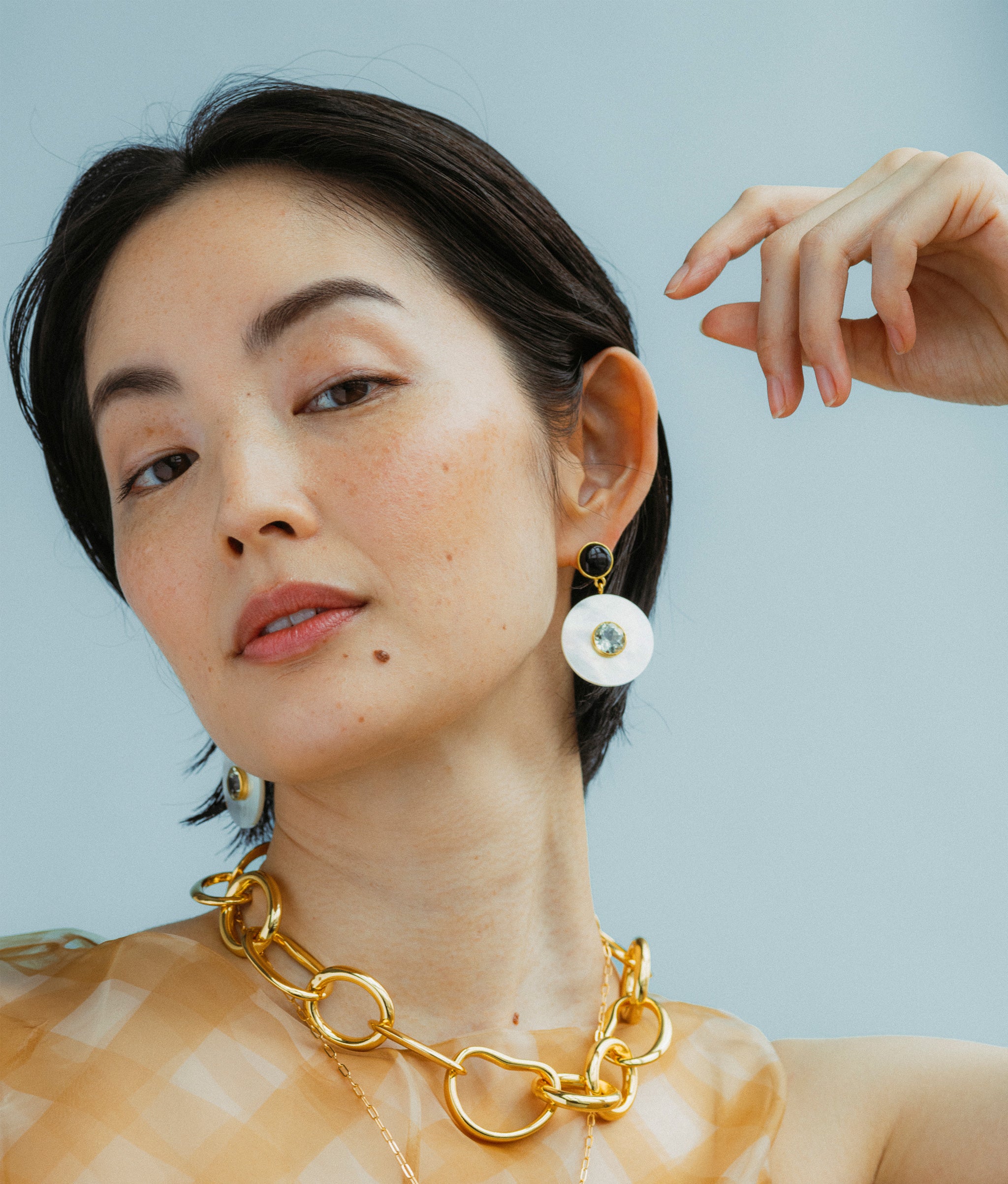 Model wears Taj Disc Earrings in Mother-Of-Pearl