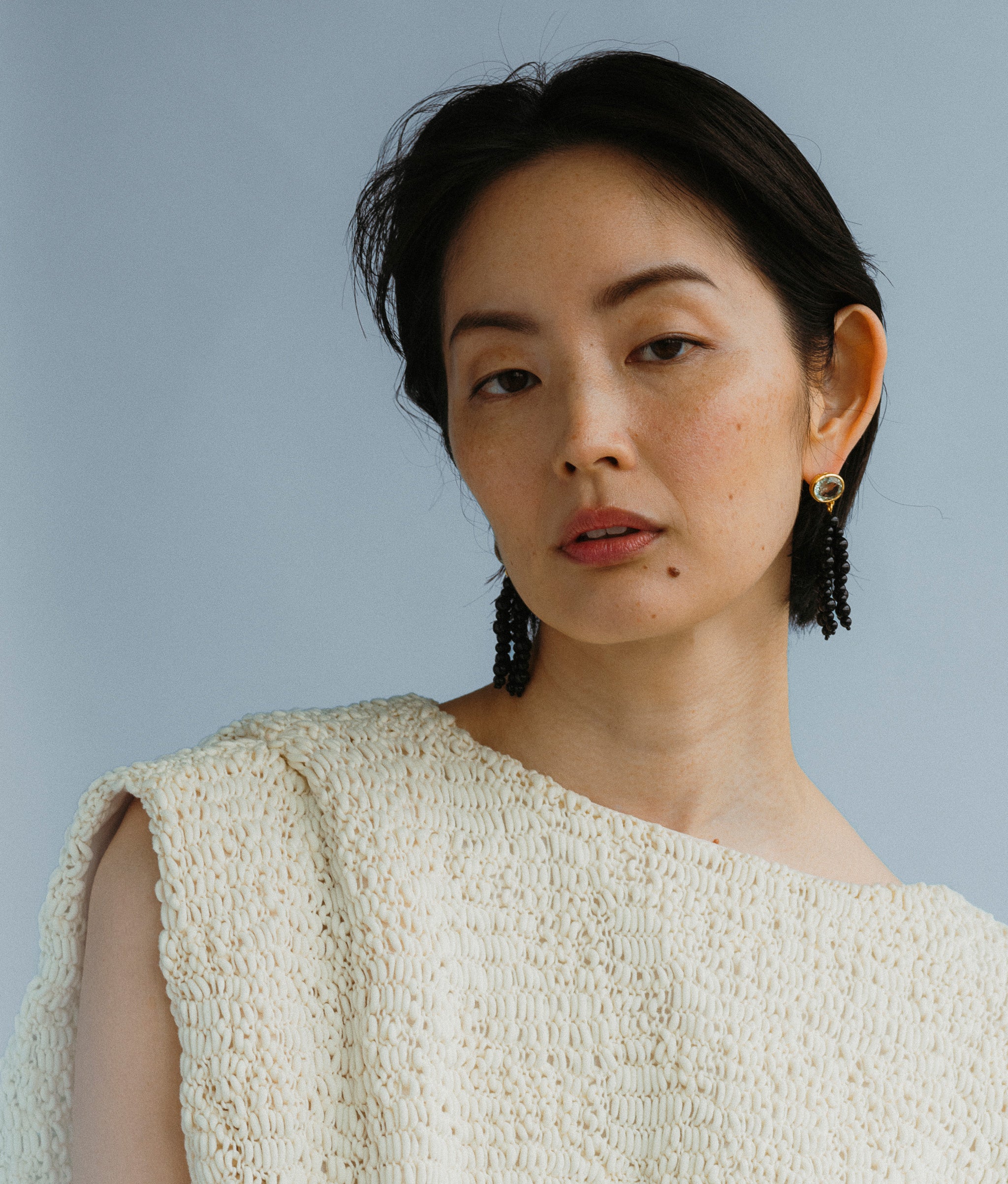 Close-up of model wearing Midnight Masquerade Earrings.