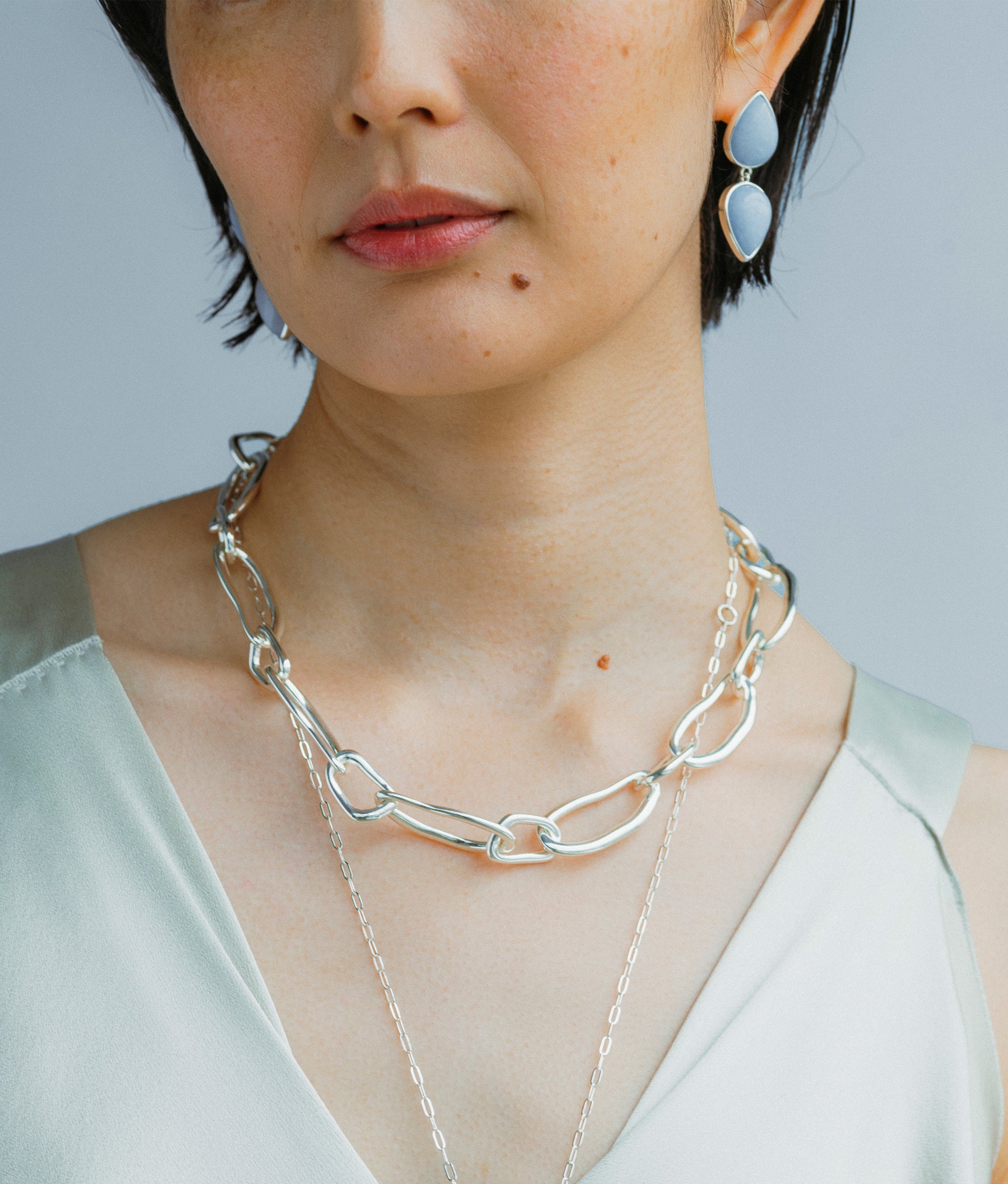 Close-up of model wearing Electra Earrings in Angelite and Collage Chain Necklace