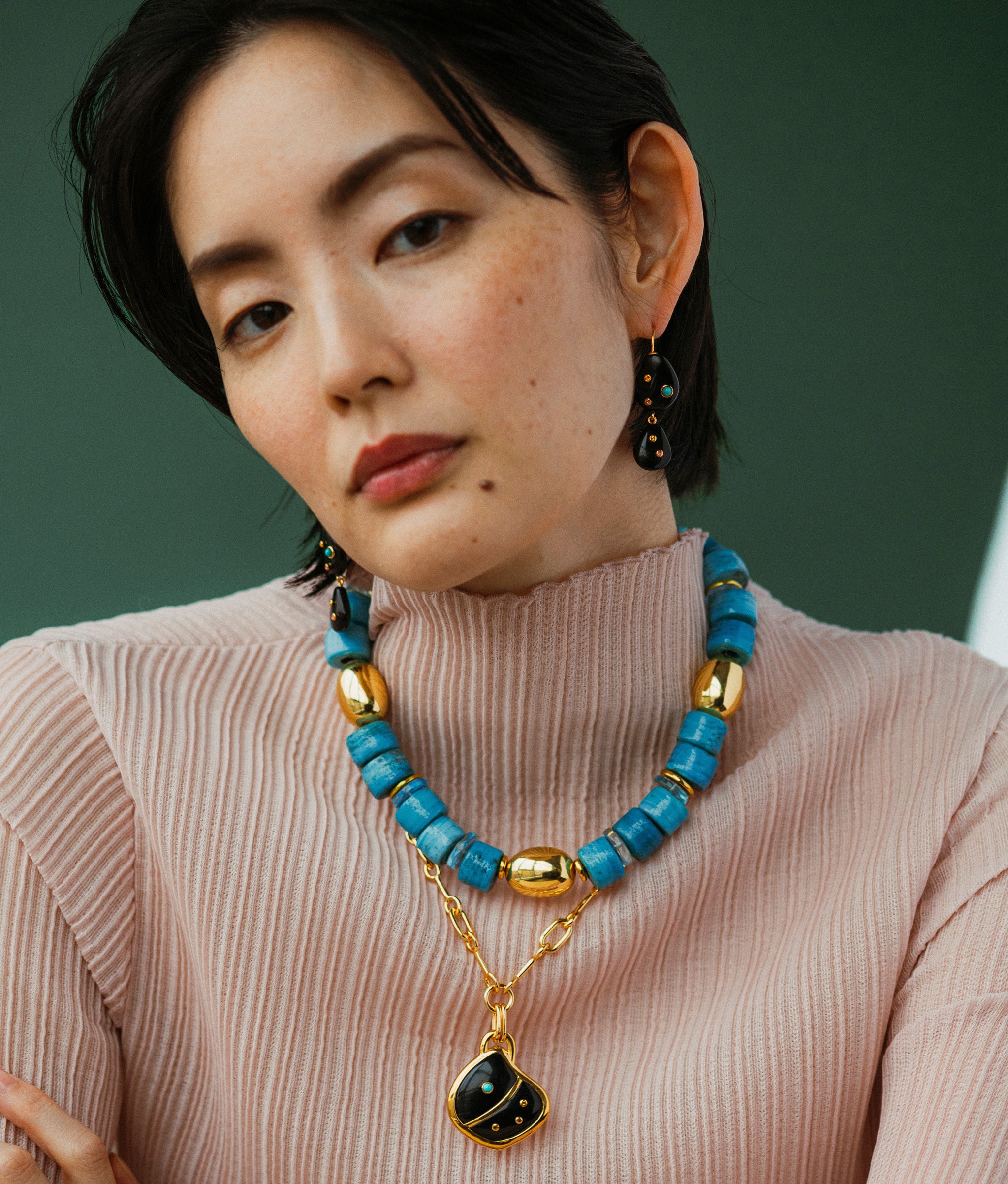 Model wears Varuna Collar layered with Agate Shell Pendant Necklace and earrings.