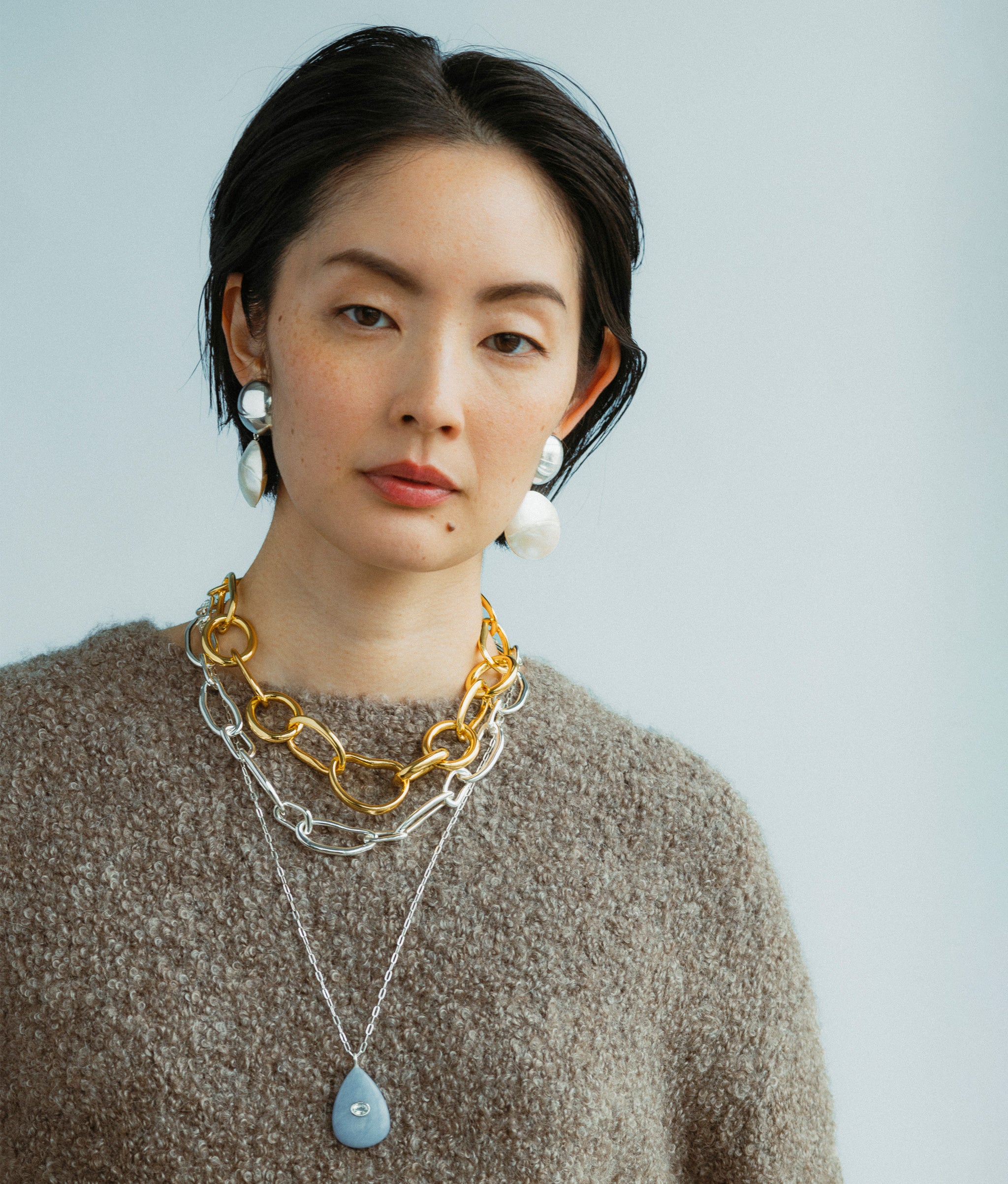 Model wears Collage Chain Necklace In Silver with Rodan Pearl Earrings in Silver, Porto Chain and Avalon Necklace.