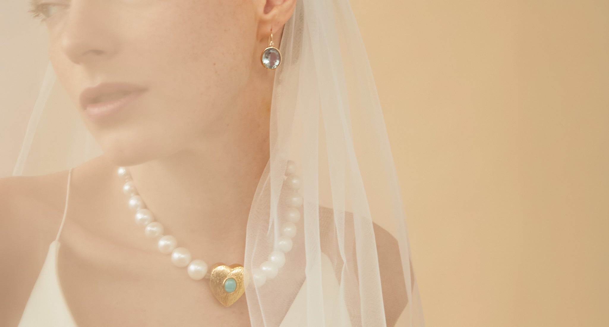 Model wears semitransparent veil with Pool Earrings and Gemini Collar