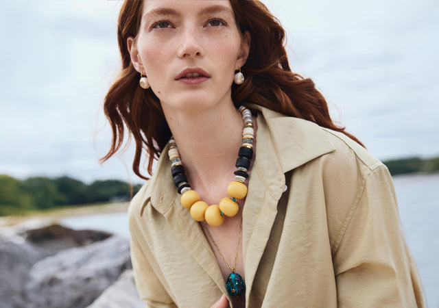 Model outdoors wears tan shirt with Pomelo Bead and Manami Necklaces