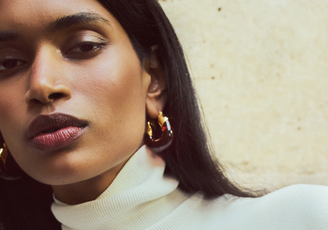 Model wears Organic Hoops in Tortoise with white turtleneck