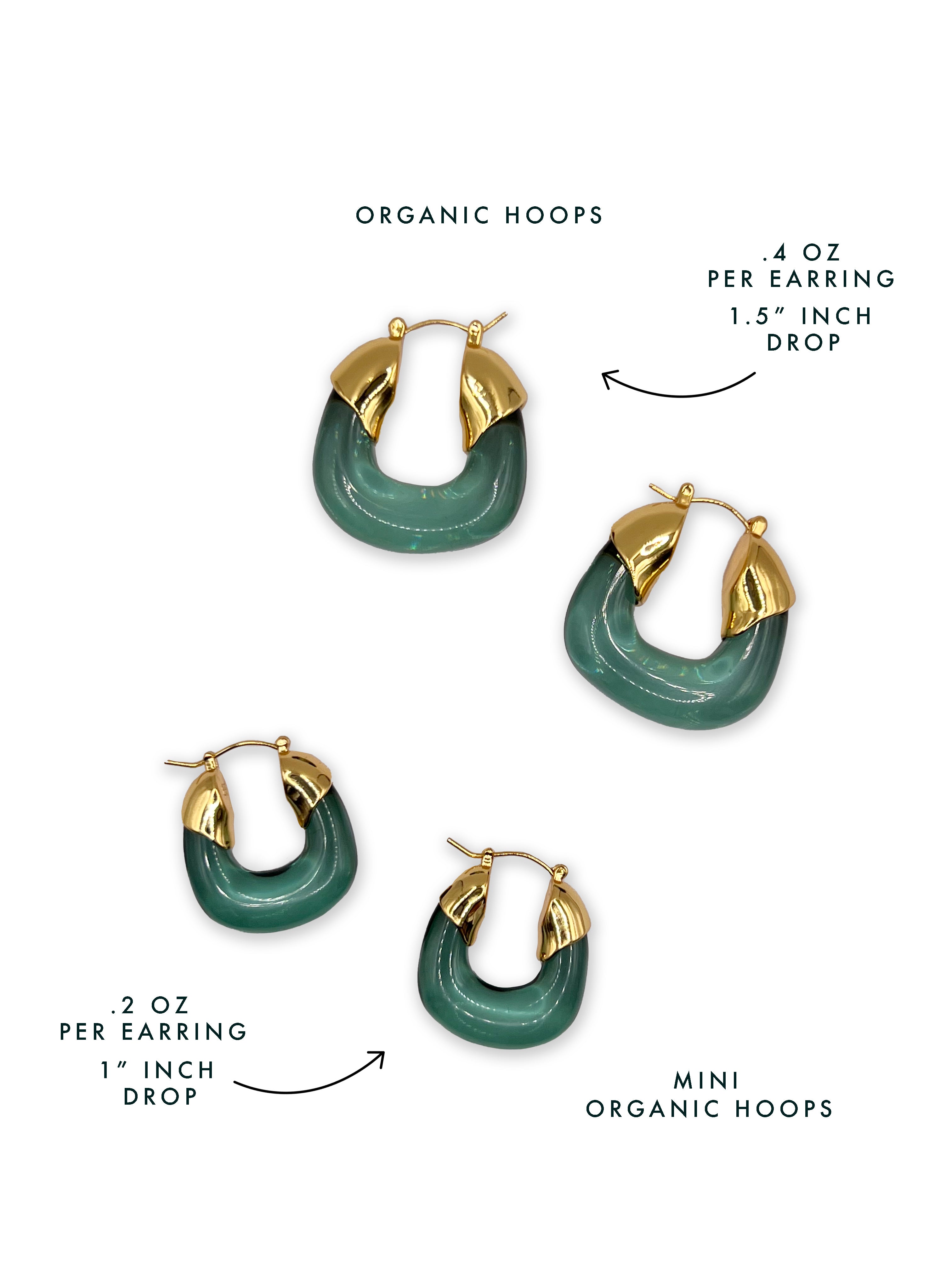 A white backgrounds shows the difference in sizing between Mini Organic Hoops and Organic hoops. 

