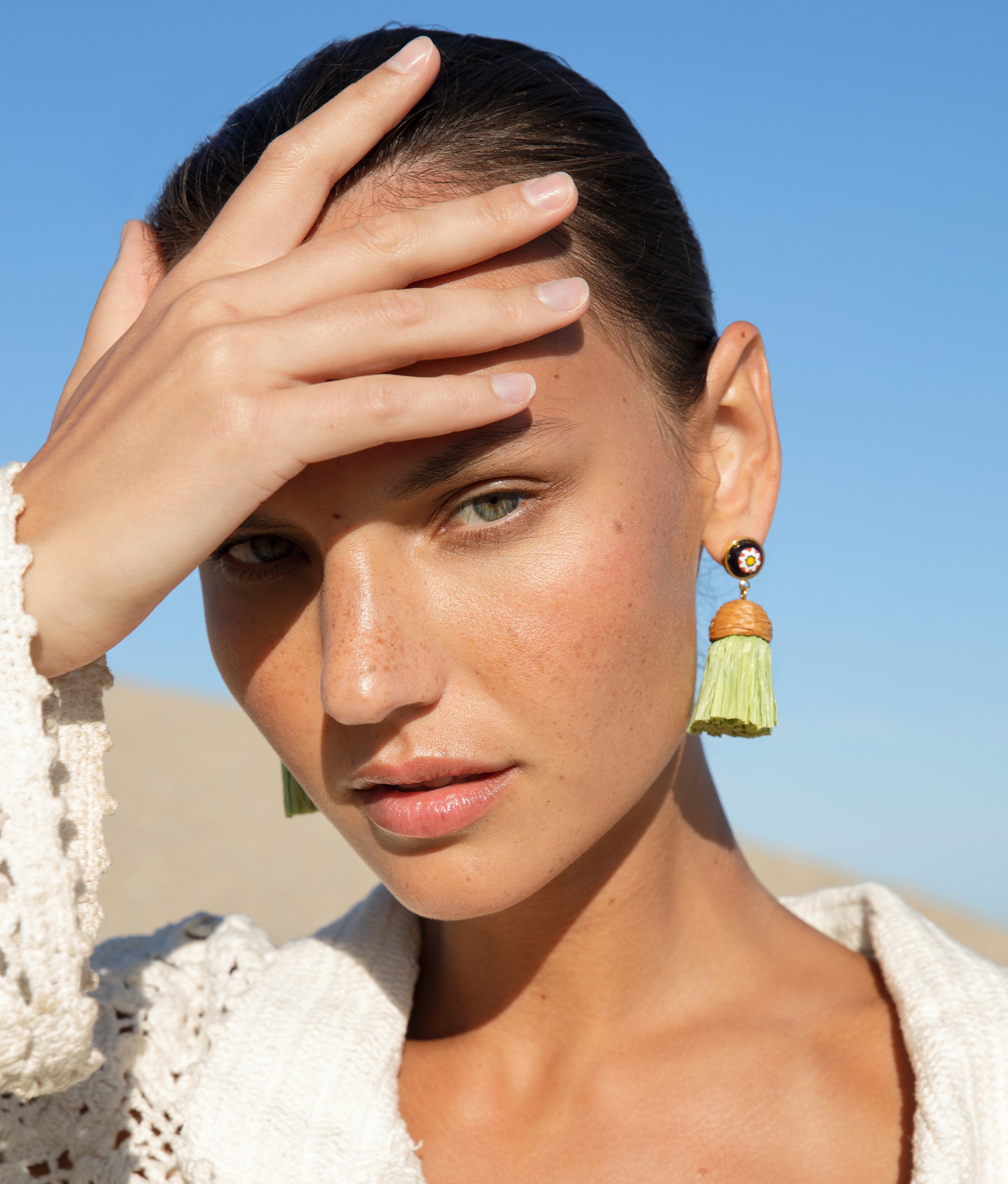 Close-up of model at the beach wearing the Raffia Earrings in Floral Palm.