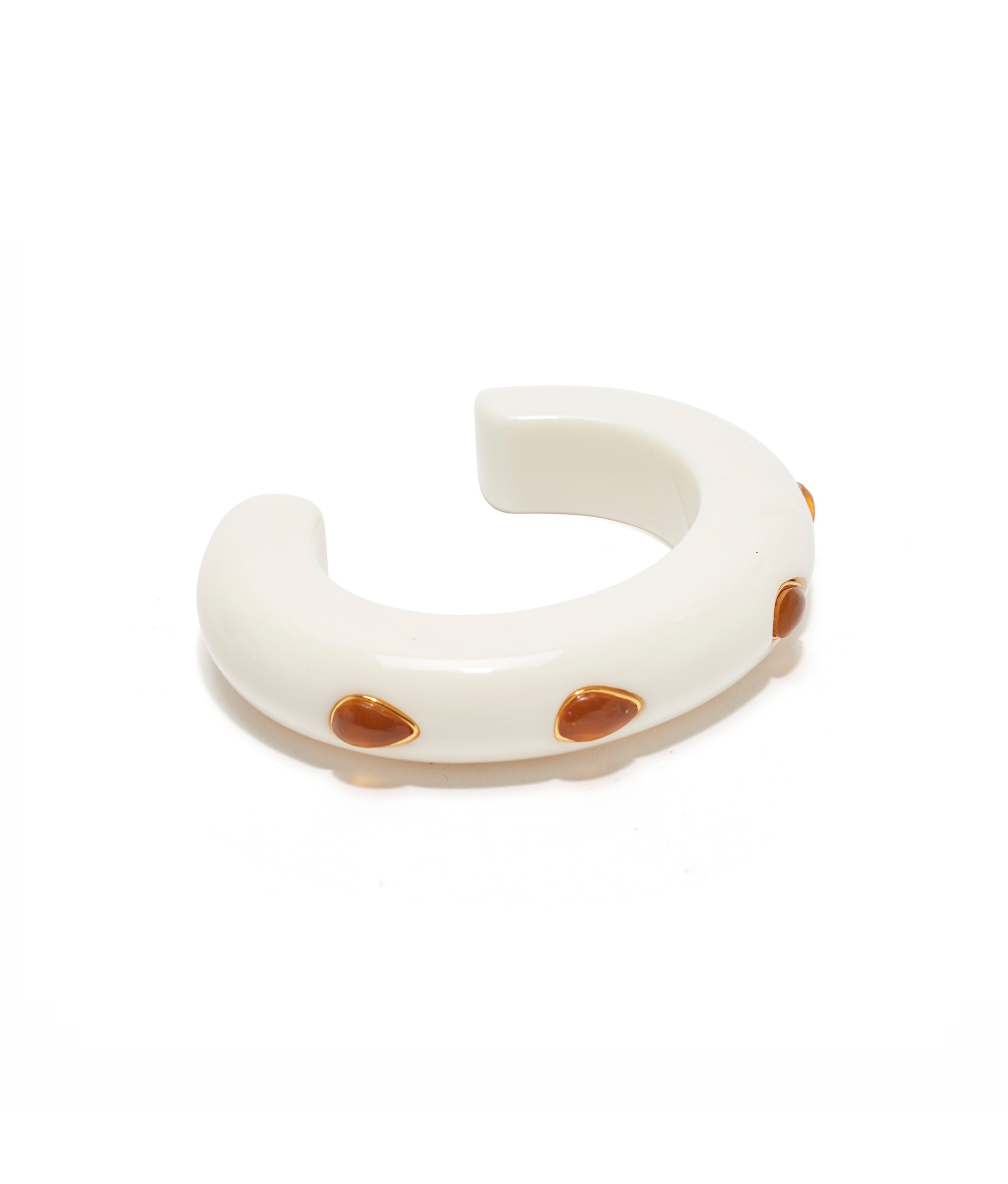 Ivory-colored, thin acrylic domed cuff with gold-plated brass bezels inlaid with amber recon stones.