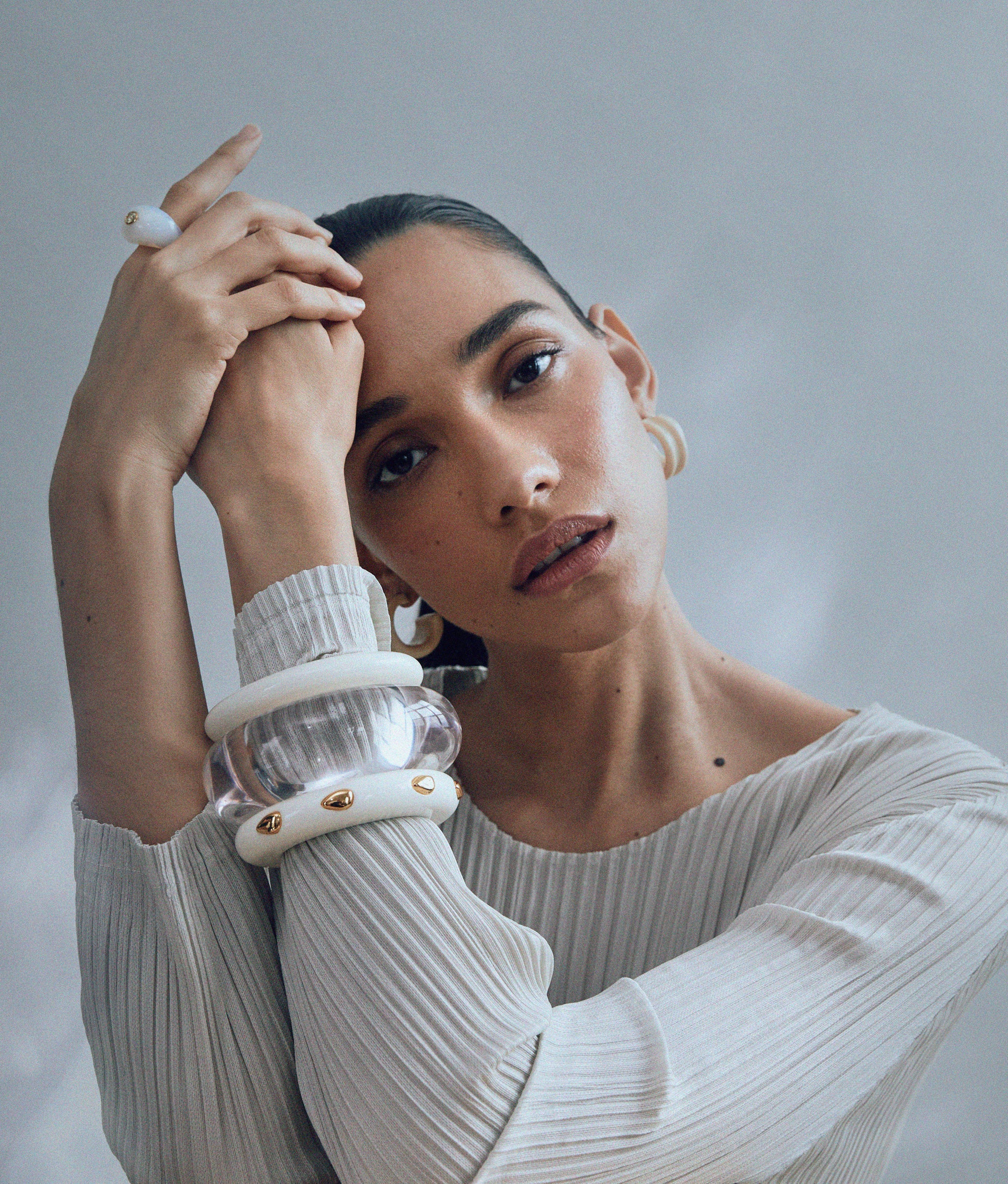 Model wears Ridge Cuff in Alabaster and Amber and Ridge Cuff in Alabaster and Gold Stud. 