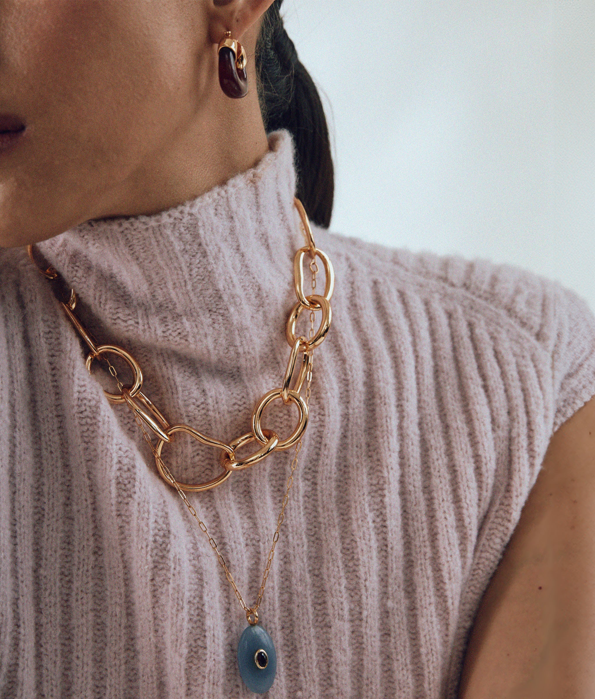 Close-up of model wearing Mini Organic Hoops in Currant styled with Porto Chain and Atelier pendant Necklace.