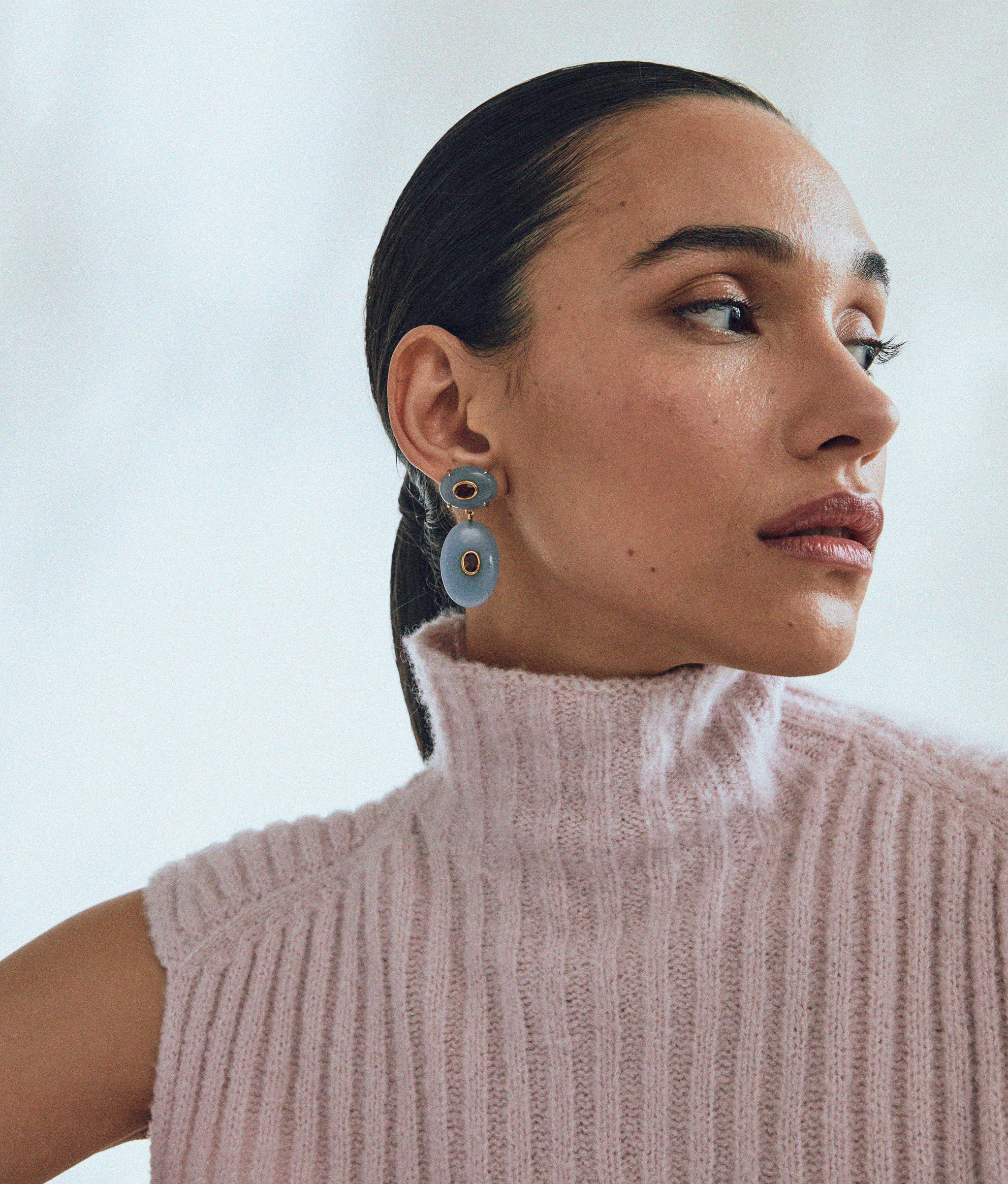 Model wears Dorothy Earrings in Angelite stone inlaid with pink rhodolite semiprecious stones.