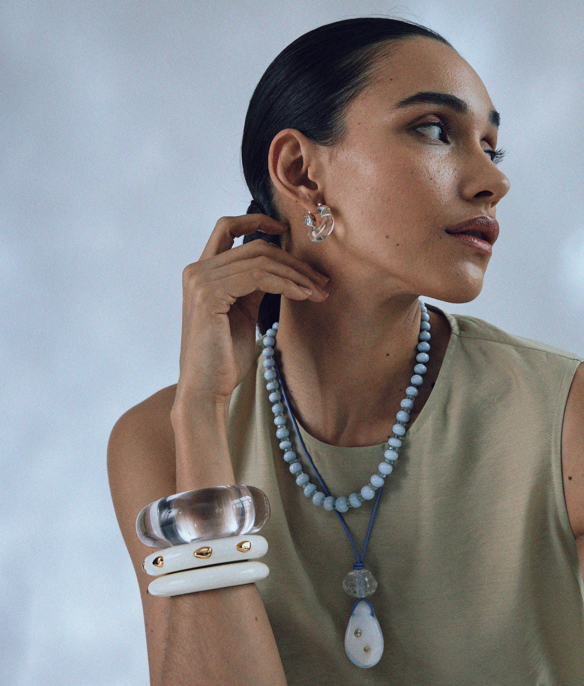 Model wears Seaside Cliffs Necklace layered with Matilde Cord Necklace and styled with cuffs.