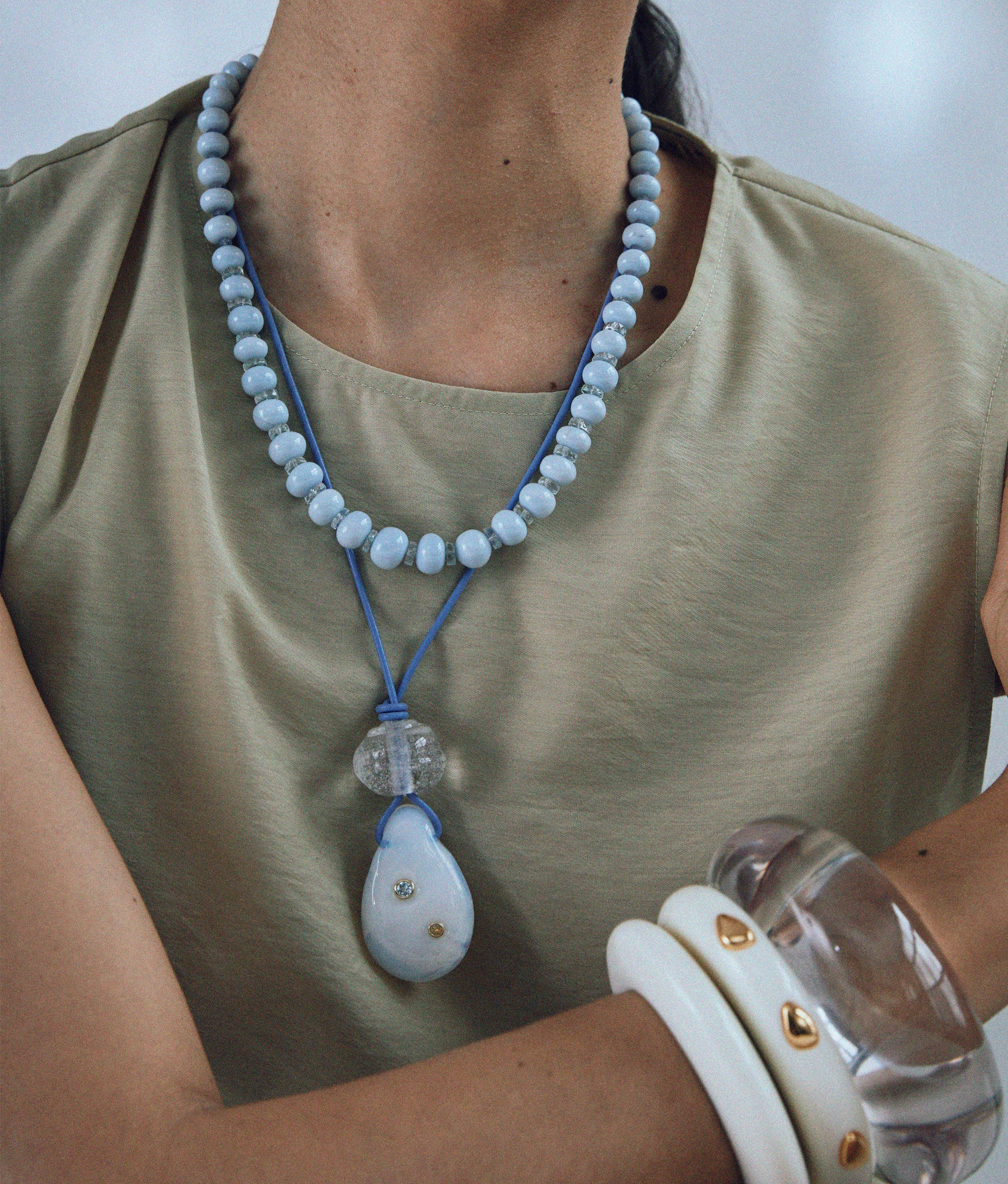 Model wears Seaside Cliffs Necklace layered with Matilde Cord Necklace and styled with cuffs.