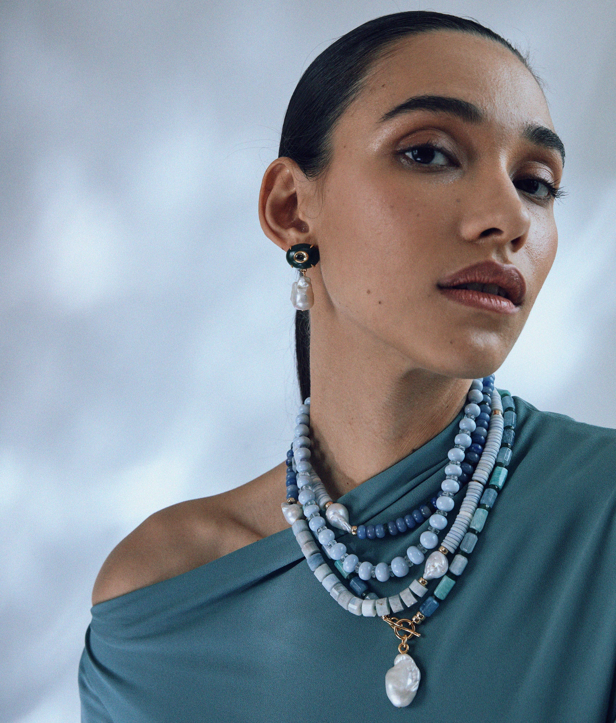 Model wears Seaside Cliffs Necklace layered with Pearl Isle Necklace in Sea and Plaza Pearl Earrings in Jade.