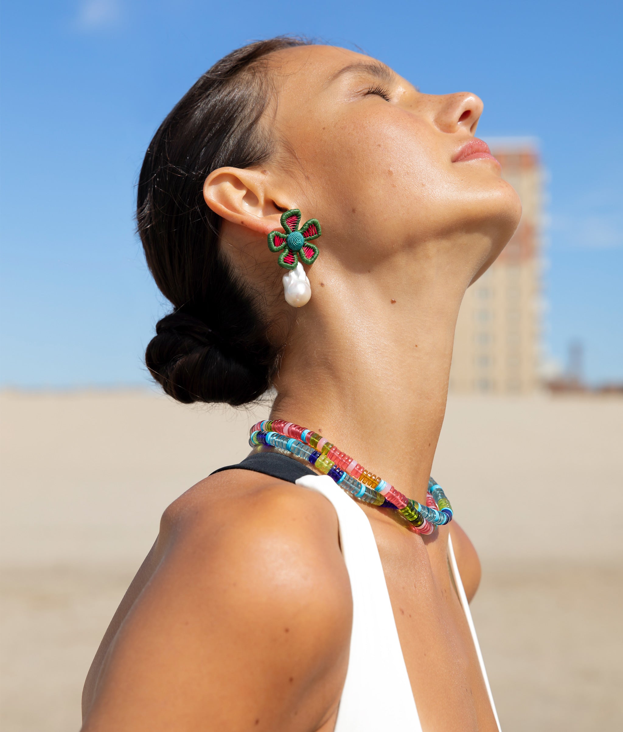 Model shown wearing Crown Daisy Earrings in Macaw paired with Agosto Necklaces in Watermelon and High Tide.